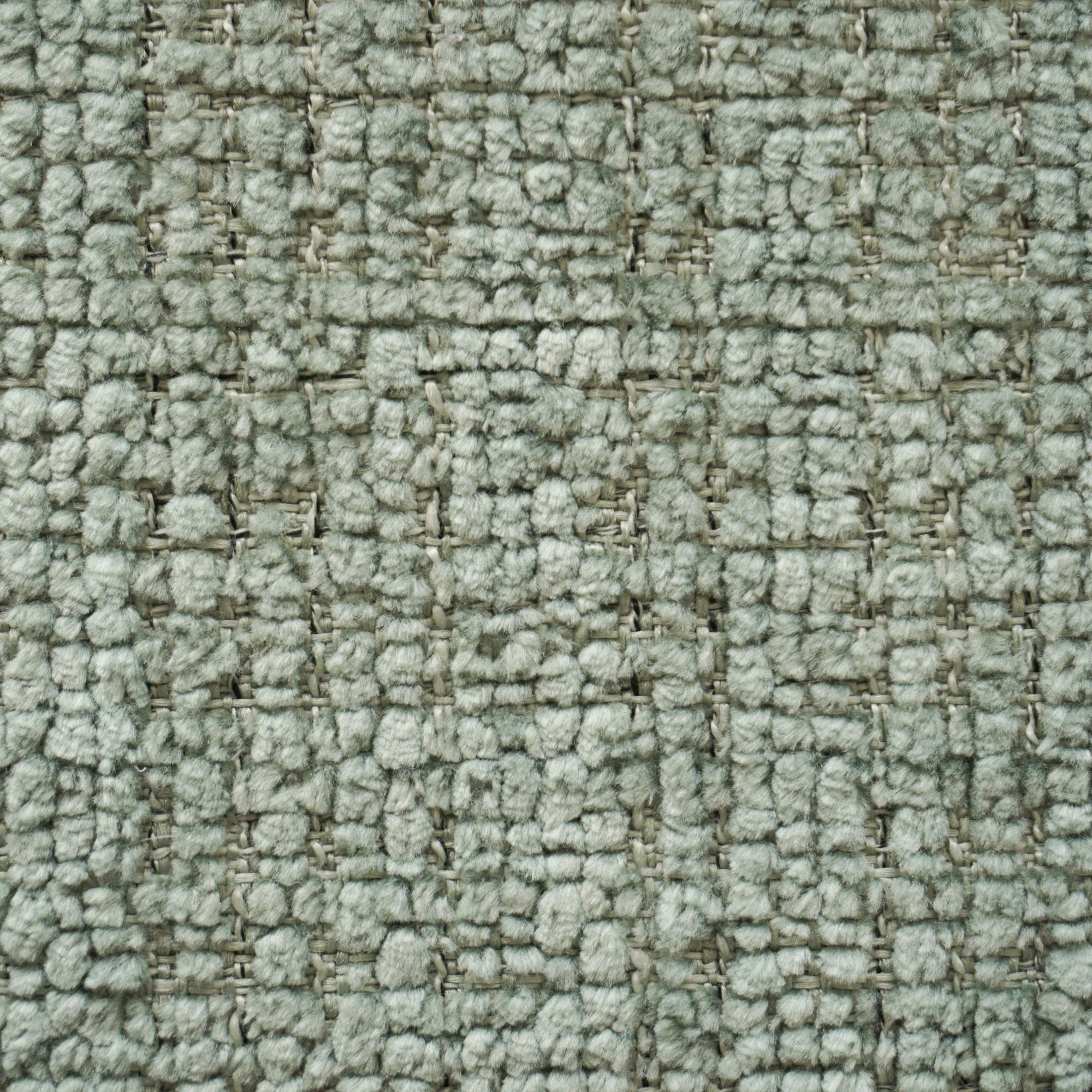 Primo piano del tappeto T28 River Eleganza materica di Divani.Store, un tappeto grigio chiaro con motivo a quadri. La trama a rilievo, le fibre antimacchia e il protettore di superficie offrono una texture ricca e profonda sotto una luce soffusa.