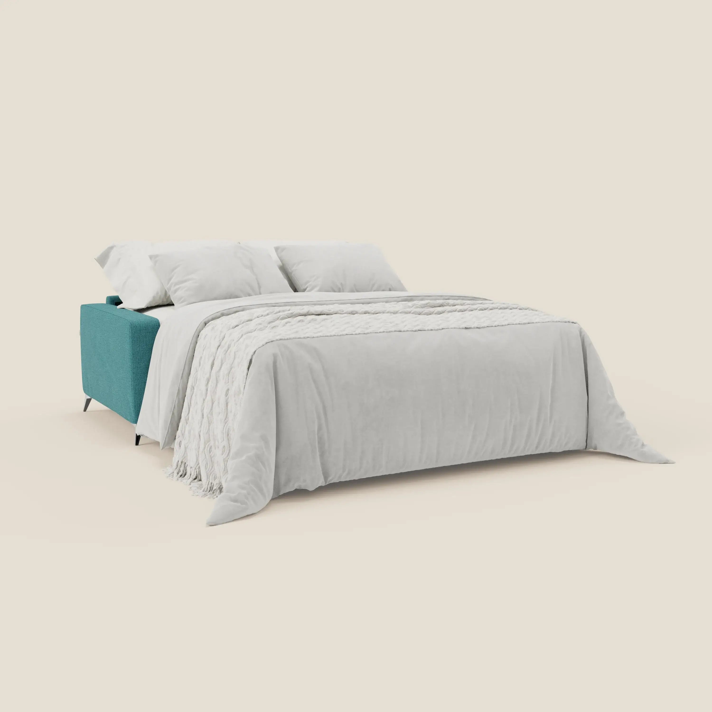 Il letto matrimoniale Alaya Divano di Divani.Store, in tessuto impermeabile T03 azzurro, è aperto a letto con plaid grigio chiaro e tre cuscini bianchi, su sfondo beige minimalista senza decorazioni.