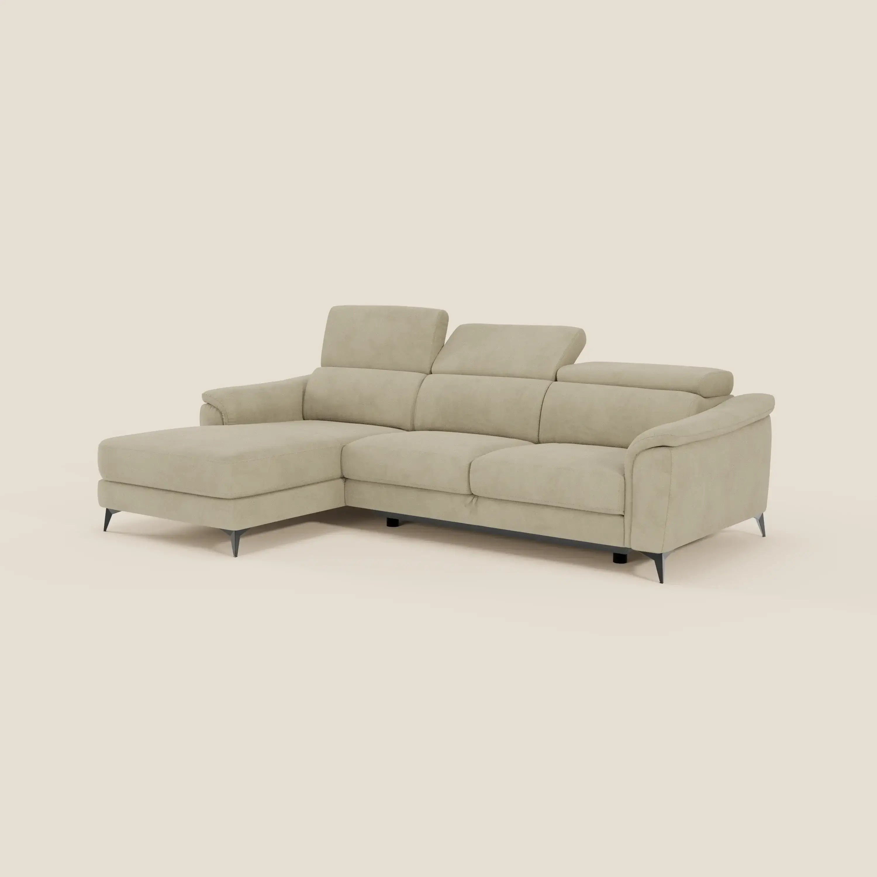 Arcos Divano con penisola di Divani.Store è un divano a L in microfibra beige con gambe alte, poggiatesta regolabili e ampi braccioli. La sua chaise lounge sul lato sinistro offre un comfort rilassante, sullo sfondo di un semplice sfondo color crema.