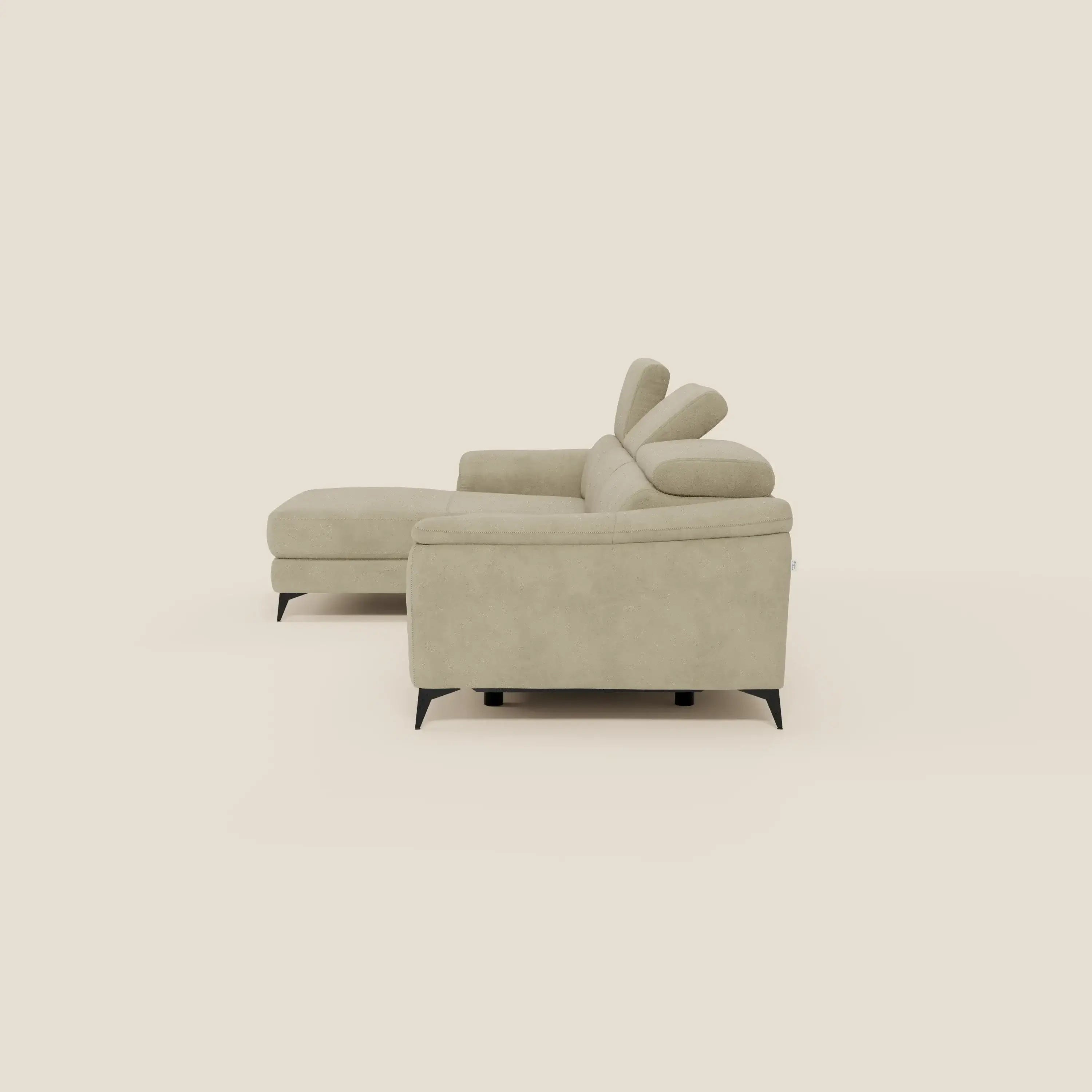 L'Arcos Divano con penisola di Divani.Store, in microfibra impermeabile beige T11, è caratterizzato da alte gambe nere, poggiatesta reclinabili e chaise longue per un maggiore comfort. In mostra su uno sfondo bianco sporco.