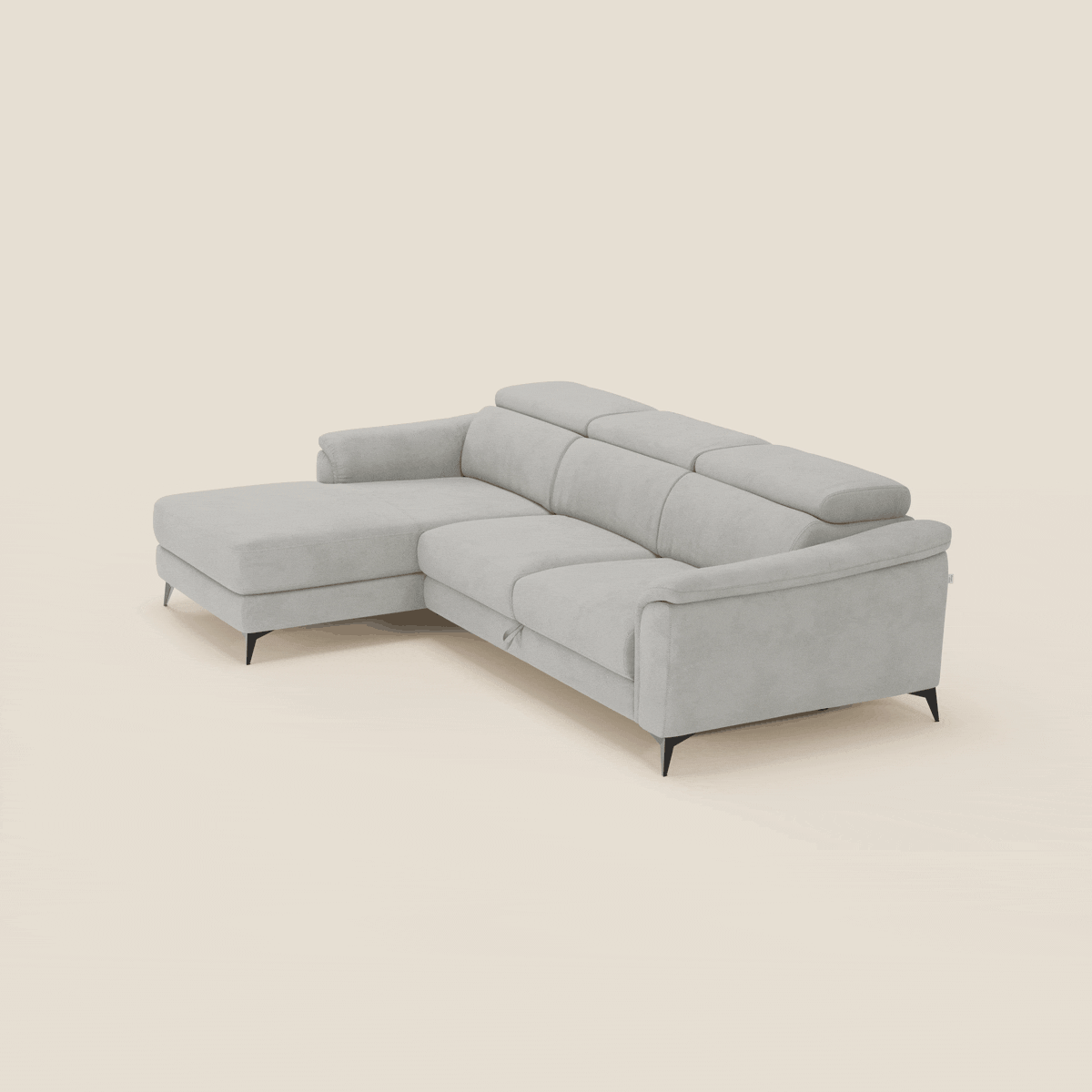 Il divano Arcos con penisola di Divani.Store è caratterizzato da poggiatesta regolabili, gambe alte in metallo nero, braccioli bassi e rivestimento in microfibra impermeabile grigio chiaro T11. La chaise longue sinistra offre una seduta spaziosa e contemporanea su uno sfondo bianco sporco.