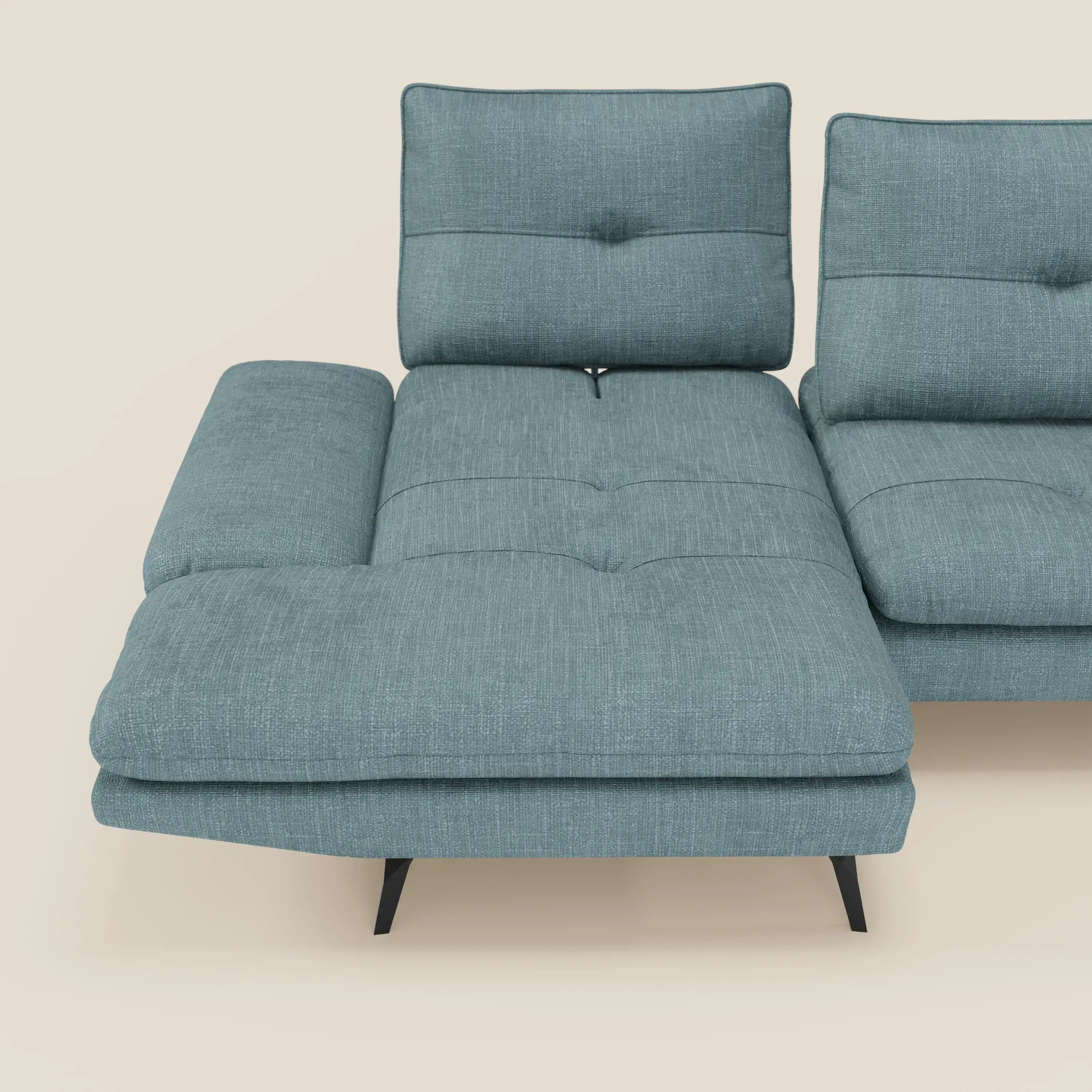 Il Divano con penisola Ardex di Divani.Store è caratterizzato da schienali traslanti, braccioli regolabili e cuscini trapuntati in elegante tessuto impermeabile T06 azzurro. Le gambe angolate nere completano il suo look moderno, su uno sfondo beige chiaro.