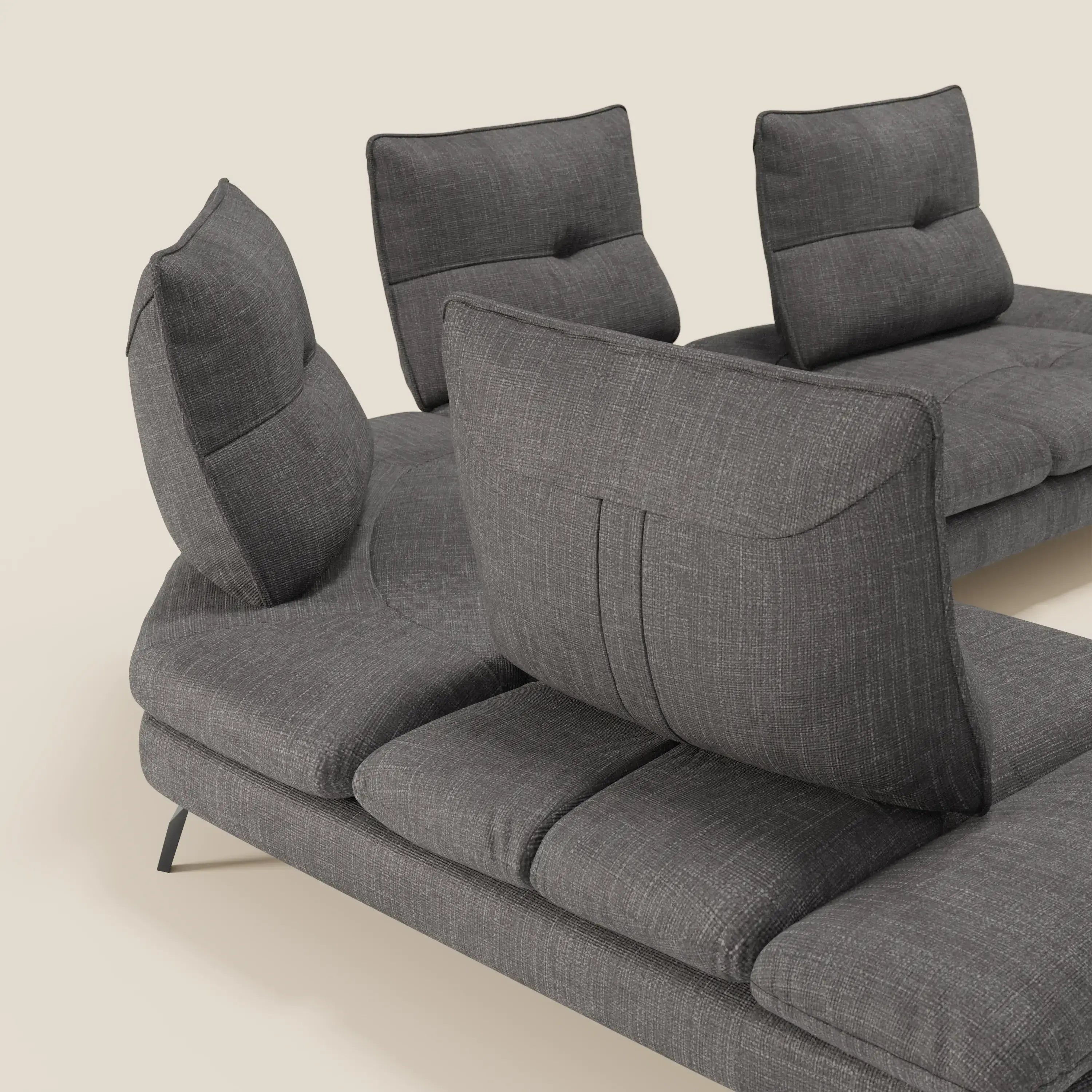 Il Divano Angolare Ardex di Divani.Store è caratterizzato da schienali traslanti e da un bracciolo regolabile in elegante tessuto impermeabile T06 antracite, appoggiato su corte gambe in metallo nero e presentato su uno sfondo chiaro.