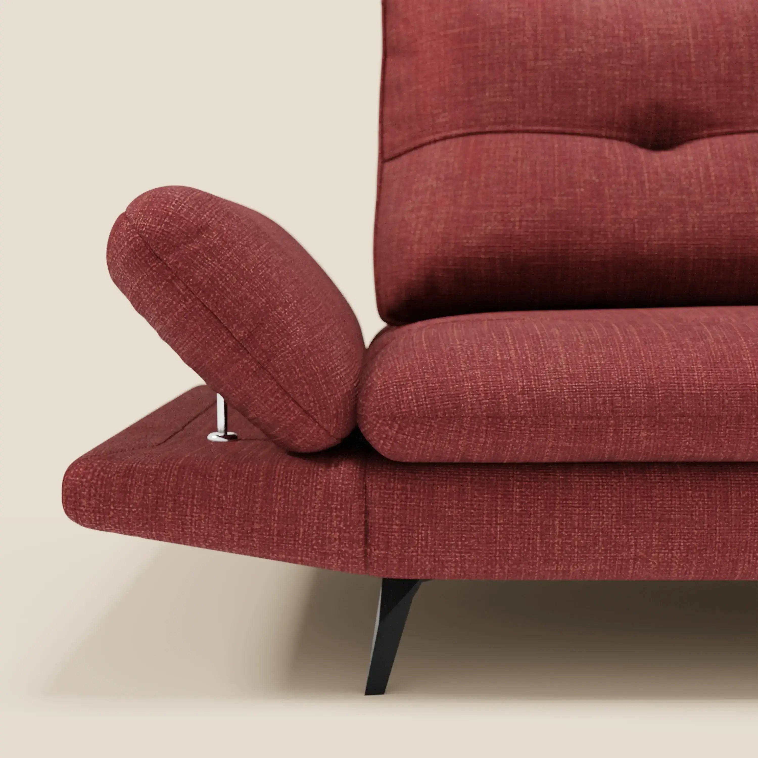 Un primo piano di Ardex Divano 3 posti di Divani.Store in tessuto impermeabile rosso T06 mostra un bracciolo regolabile inclinato. Il divano moderno ha gambe angolate nere e poggia su un pavimento chiaro su uno sfondo crema.