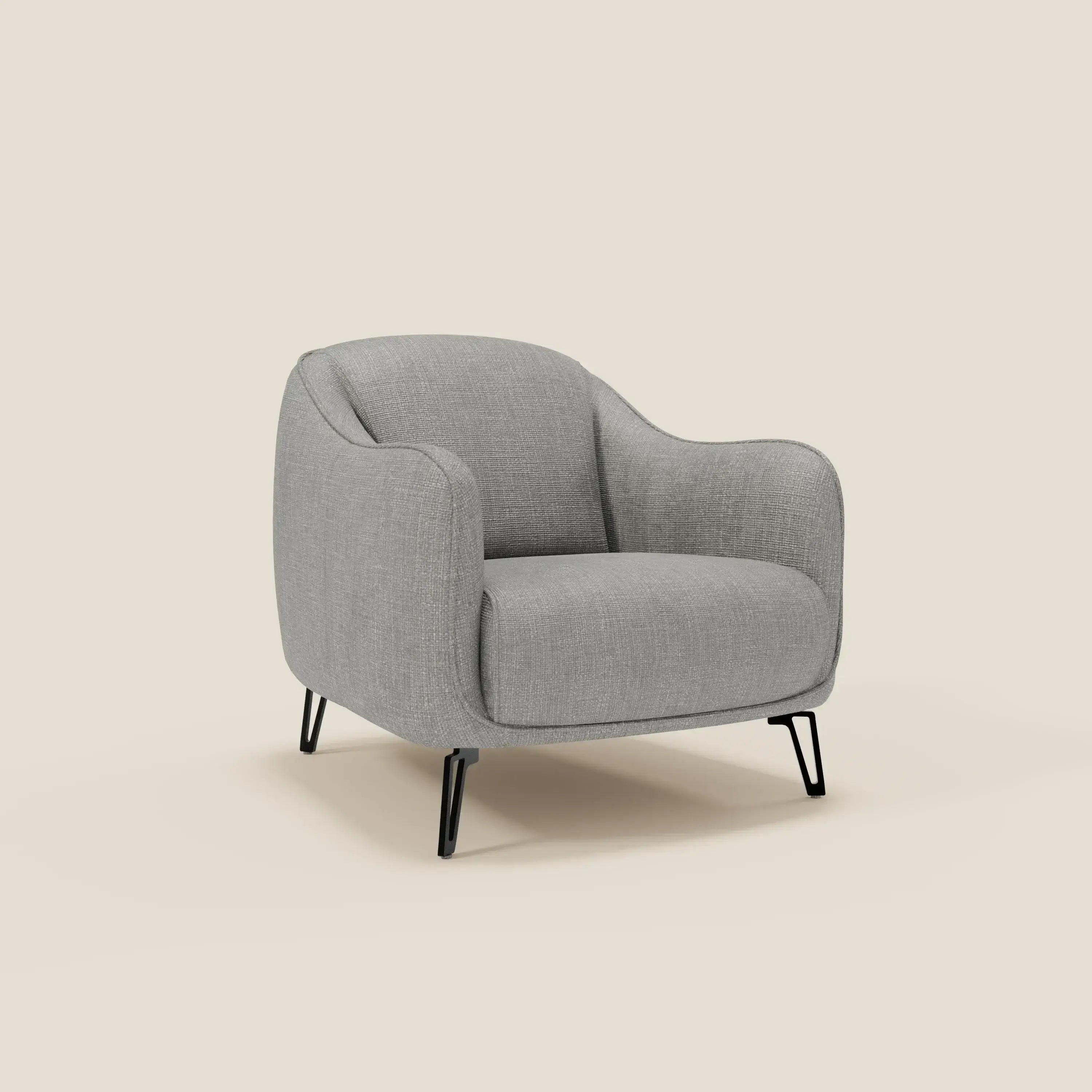 La Poltroncina Avela di Divani.Store, in morbido tessuto impermeabile T06 grigio, offre comfort senza tempo con linee arrotondate e gambe sottili nere, ambientata su sfondo beige.