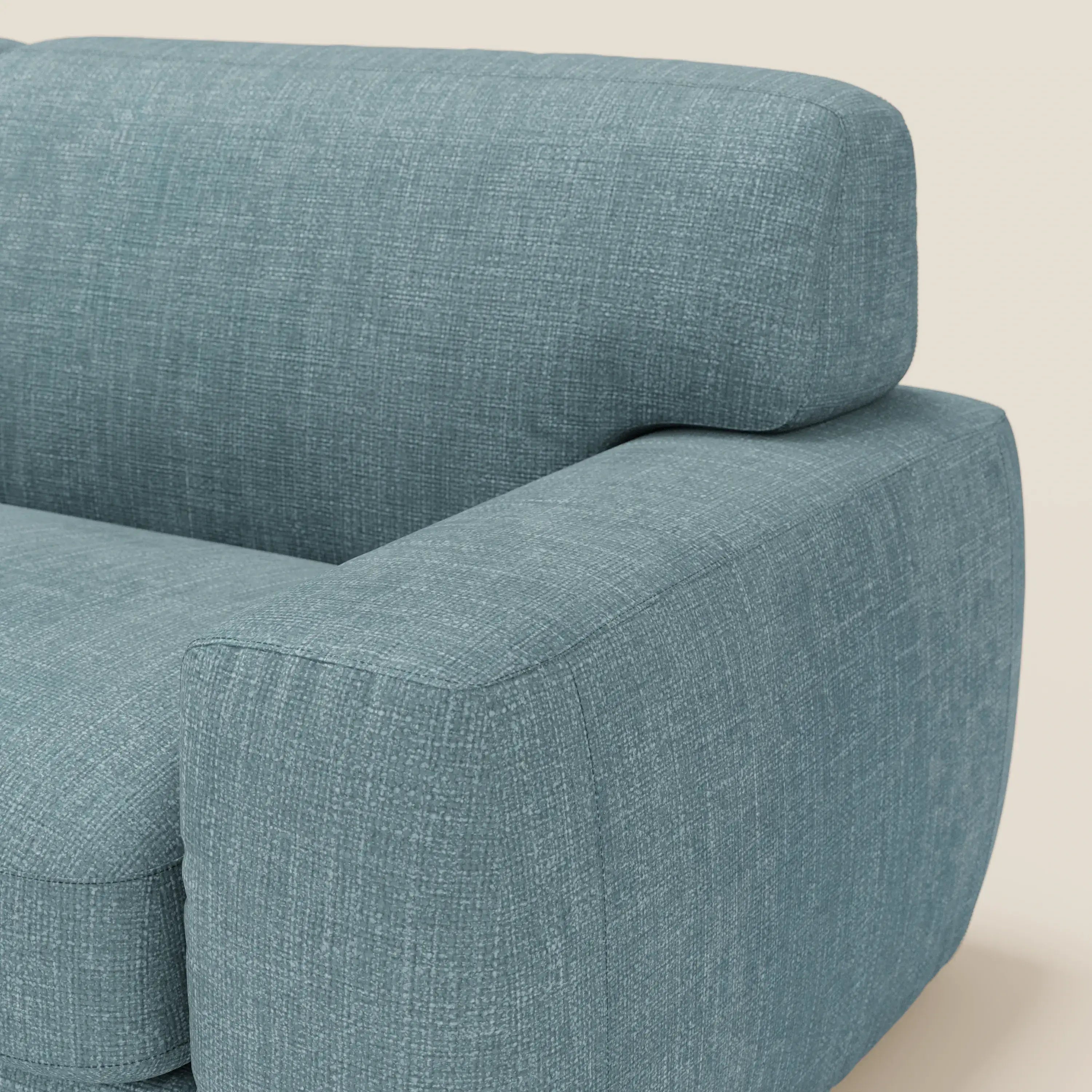 Un primo piano del letto materasso Cloud Divano H17 cm di Divani.Store, rivestito in tessuto impermeabile T06 azzurro con morbidi cuscini, presenta braccioli e schienale con spessa imbottitura per un comfort quotidiano ispirato al design moderno.