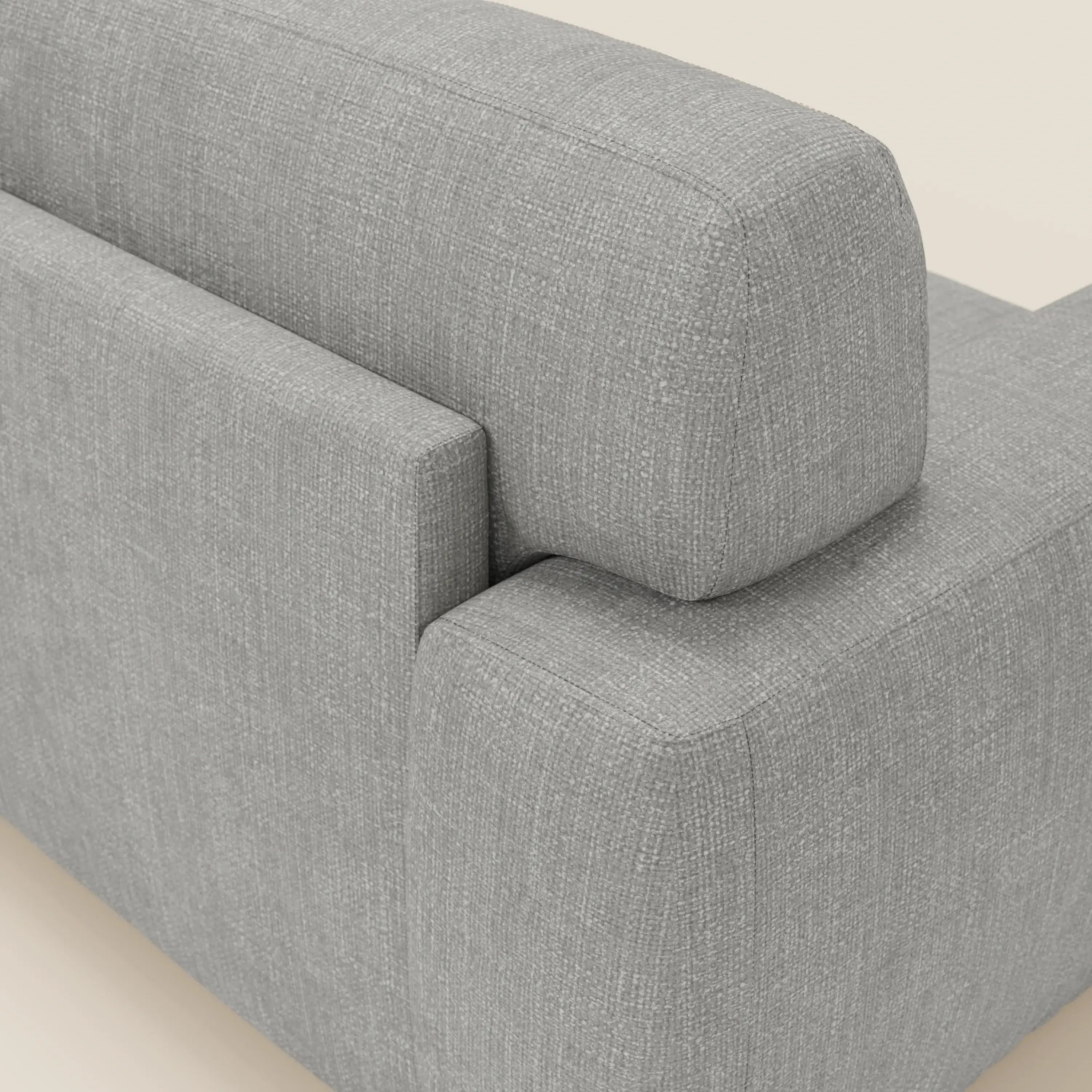 Un primo piano mostra l'angolo posteriore del letto materasso Cloud Divano H17 cm di Divani.Store, caratterizzato da morbidi cuscini in tessuto impermeabile grigio T06. Le linee pulite e il bracciolo quadrato ne evidenziano il design moderno su uno sfondo neutro.