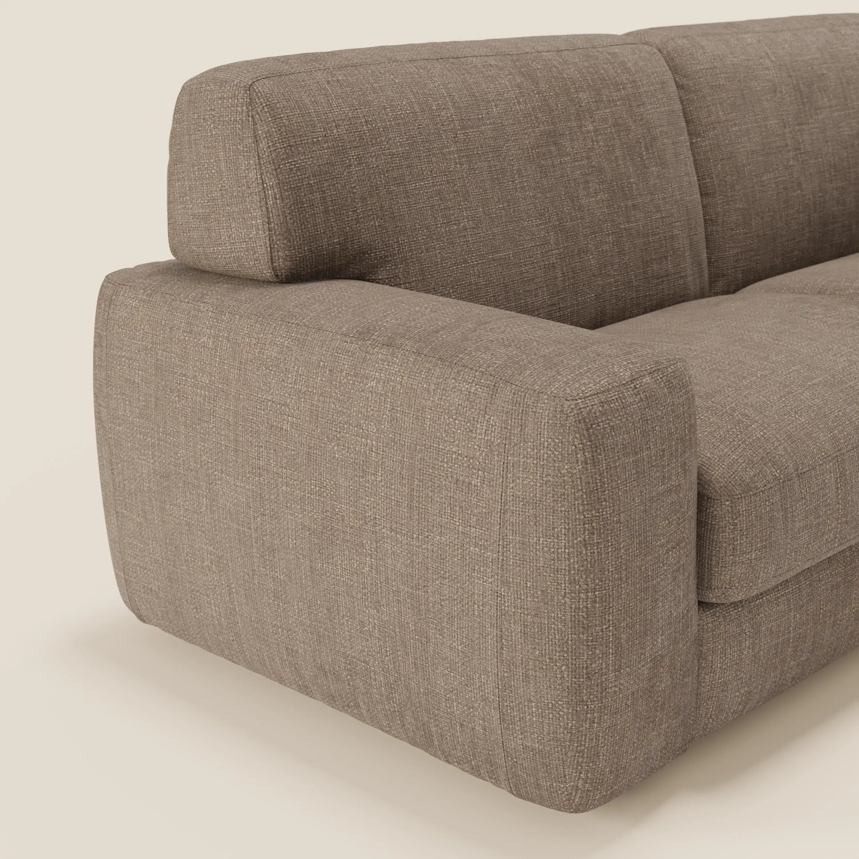 Primo piano del divano letto materasso H17 cm di Divani.Store Cloud, caratterizzato da cuscini in peluche e forma squadrata in tessuto impermeabile marrone T06. Il divano letto moderno e compatto è inserito in un semplice sfondo bianco sporco.