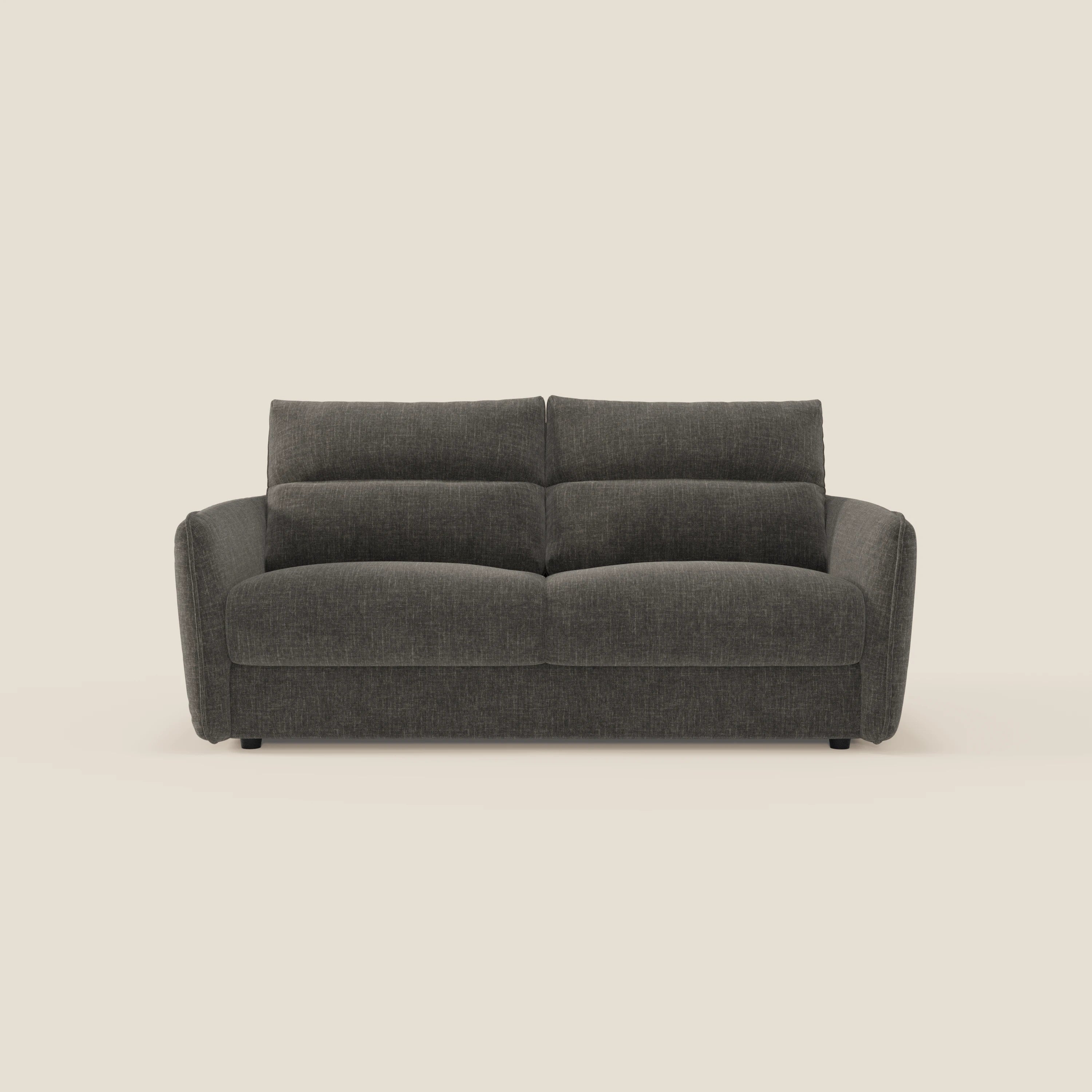 Elios Divano letto di Divani.Store è caratterizzato da ampi cuscini di schienale, spessi braccioli imbottiti, piedini corti neri e rivestimento in tessuto T24 antracite facile da pulire su uno sfondo bianco sporco.