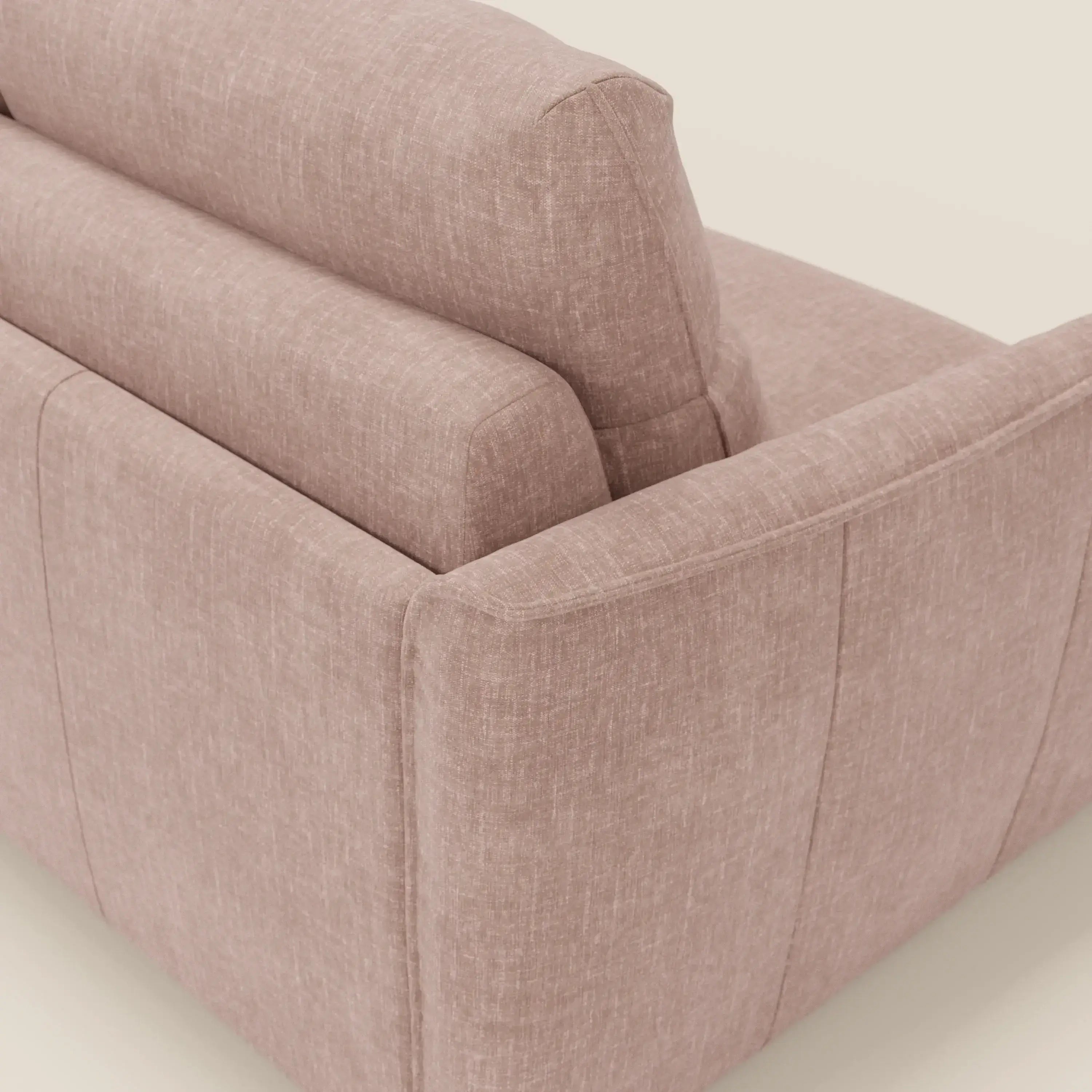Primo piano dell'angolo posteriore di Elios Divano letto di Divani.Store, rivestito in T24 rosa cipria tessuto smacchiabile. L'immagine evidenzia le linee eleganti, i cuscini dello schienale e le cuciture a vista su uno sfondo bianco sporco.