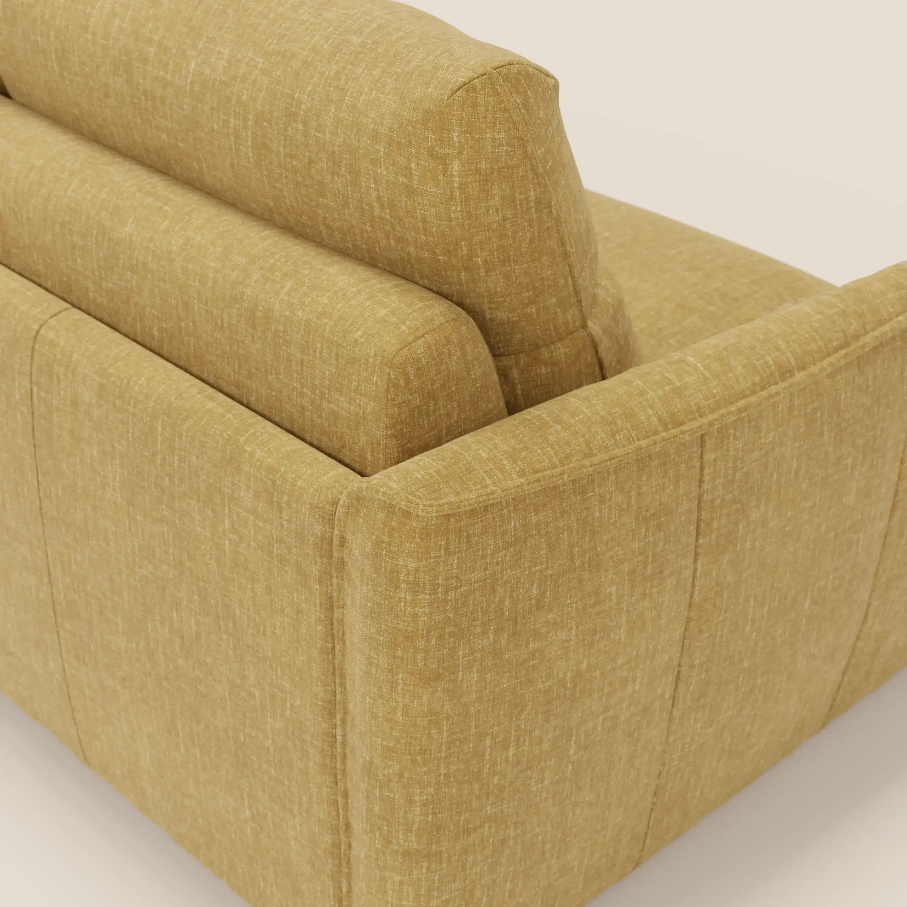 Una vista ravvicinata e angolata di Elios Divano letto di Divani.Store, rivestito in tessuto smacchiabile T24 giallo senape, mostra i morbidi cuscini dello schienale, il bracciolo e la seduta con cuciture a vista e linee pulite su uno sfondo semplice.