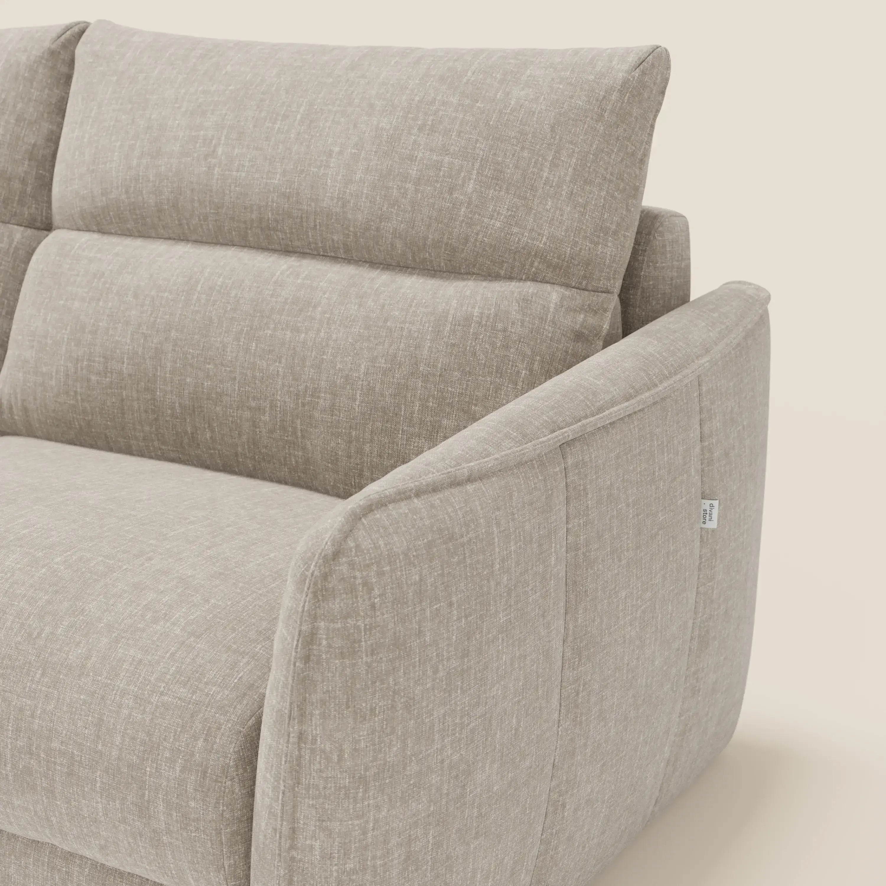 Primo piano del divano letto Elios Divano con morbidi cuscini spalliera in tessuto smacchiabile T24 lino chiaro di Divani.Store, caratterizzato da braccioli angolari e cuscini in felpa a trama sottile su sfondo bianco sporco.