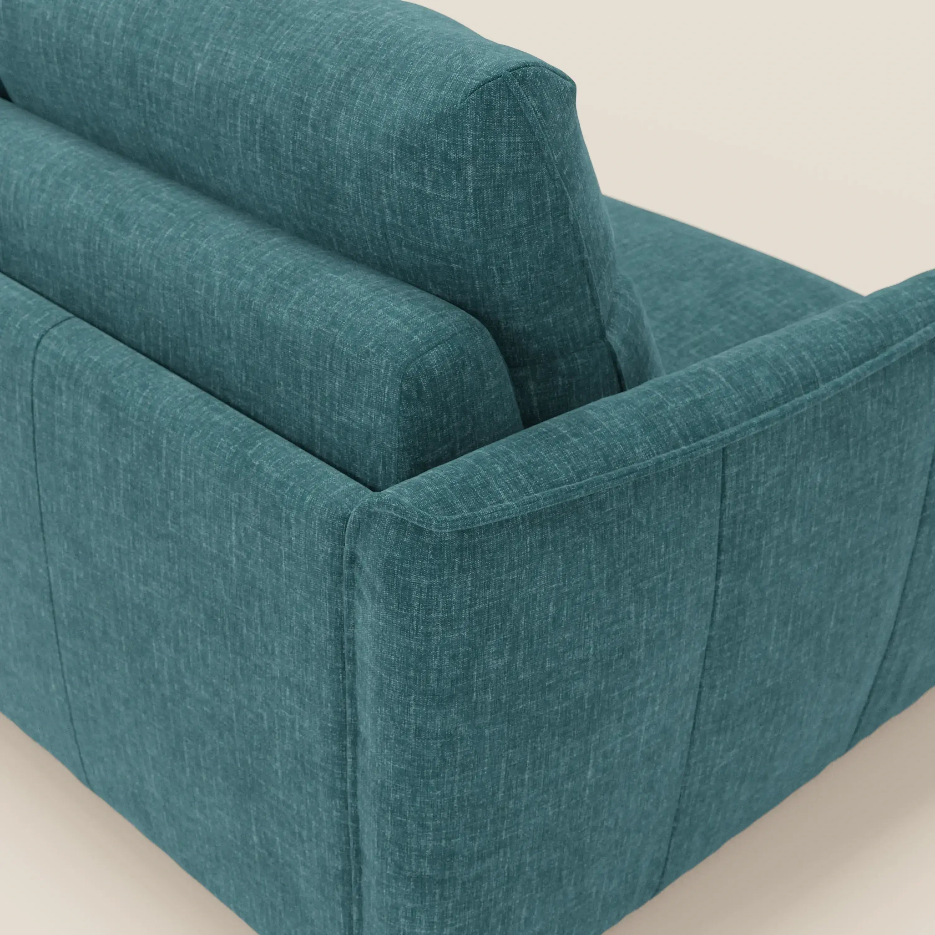 Primo piano del divano letto Elios con morbidi cuscini spalliera di Divani.Store, rivestito in tessuto smacchiabile T24 petrolio, che mostra cuciture raffinate, linee pulite e cuscini morbidi su uno sfondo neutro.