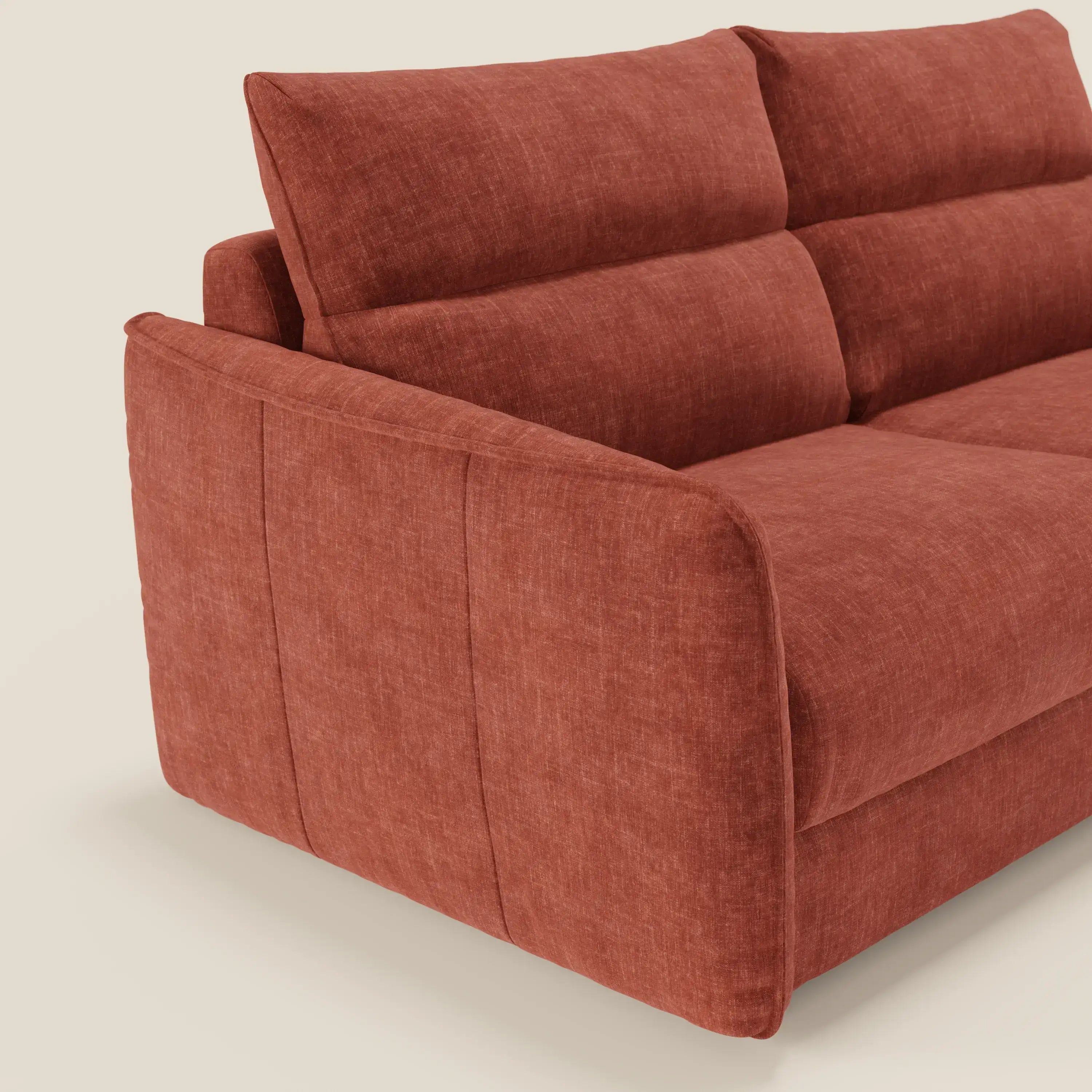 Un primo piano del divano letto Elios di Divani.Store, caratterizzato da morbidi cuscini angolari dello schienale in tessuto antimacchia T24, ampi braccioli imbottiti e sedute profonde, eleganti e invitanti su uno sfondo beige chiaro.