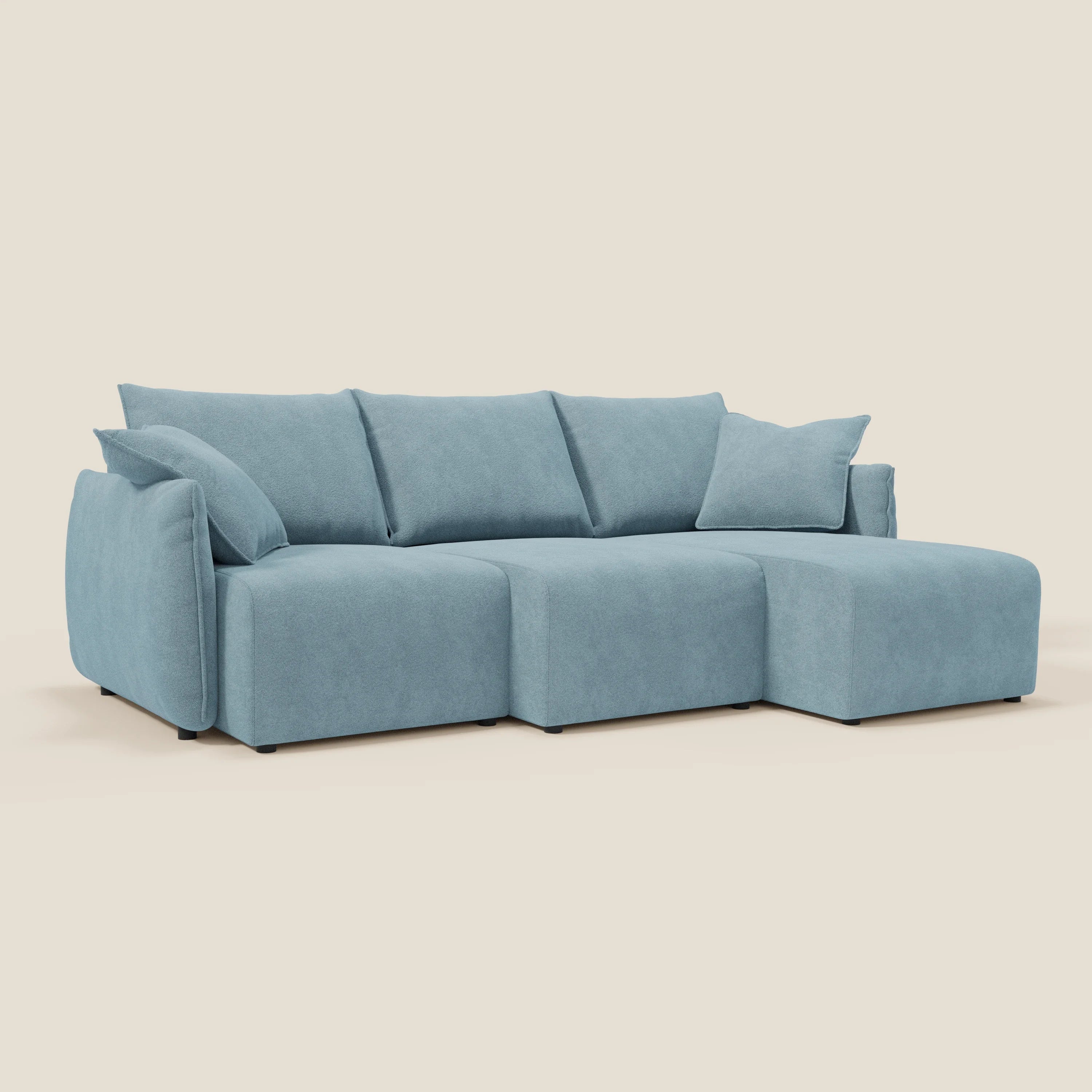 Il Flexar Divano angolare reversibile di Divani.Store è caratterizzato da un morbido bouclé blu carta da zucchero impermeabile, tre cuscini per la seduta e lo schienale, due cuscini laterali e una chaise longue per un maggiore comfort su uno sfondo color crema.