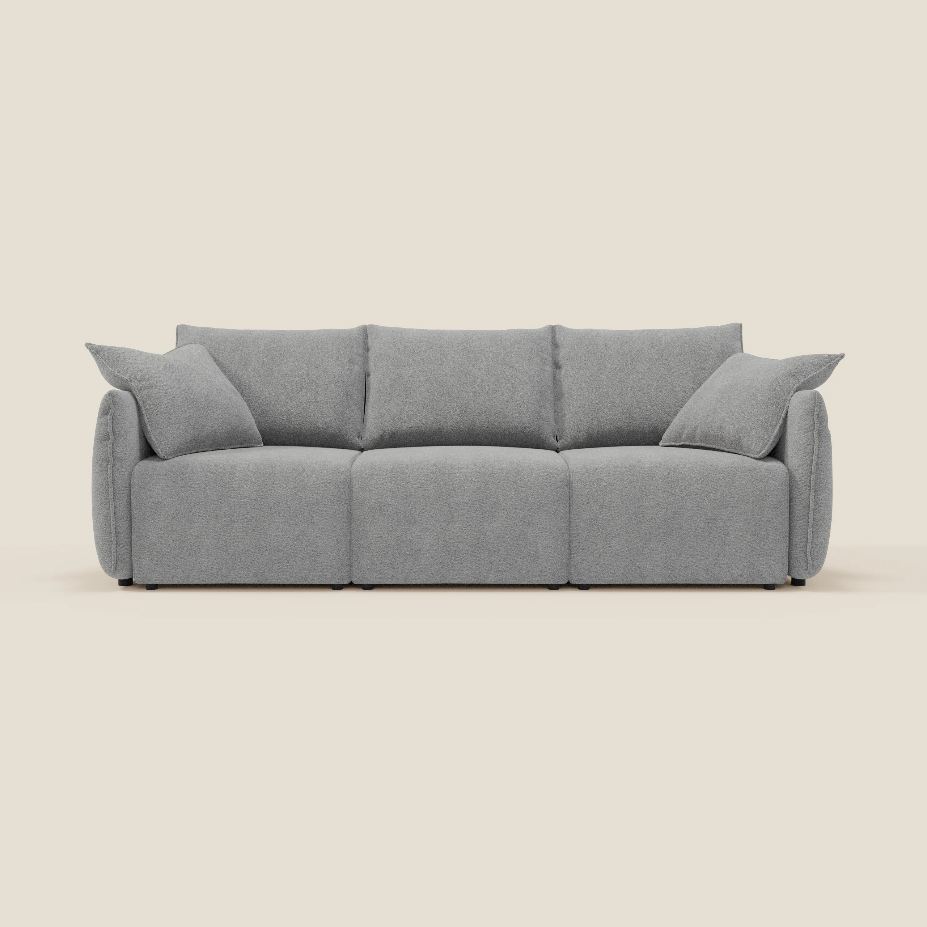 Il divano Flexar con 3 sedute allungabili di Divani.Store è caratterizzato da un bouclé impermeabile T07 grigio e da uno schienale in piuma d'oca. Due cuscini grigi coordinati accentuano le sue linee moderne e morbide su uno sfondo crema.
