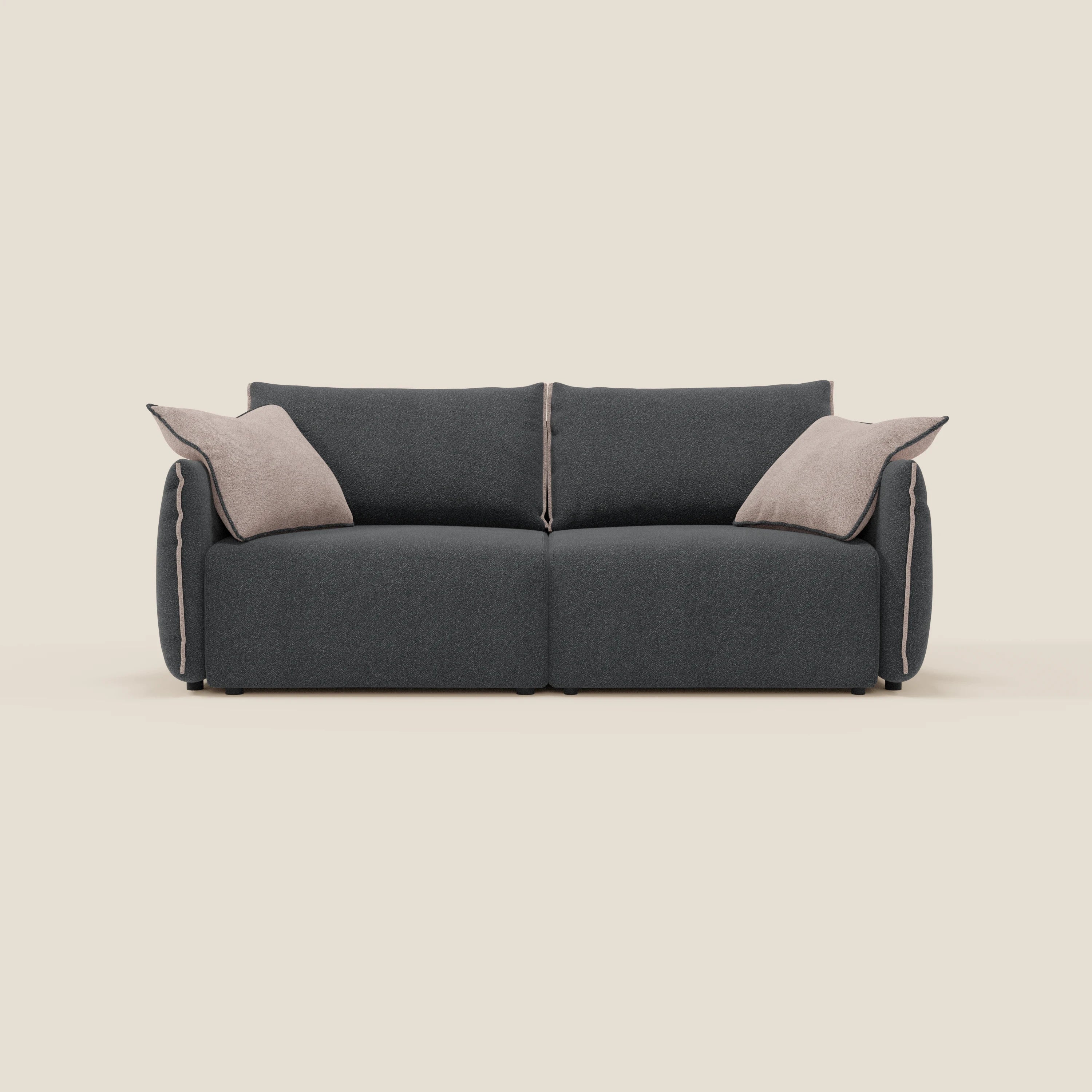 Il divano Divani.Store Flexar in bouclé impermeabile T07 antracite-rosa è caratterizzato da sedute allungabili, schienale in piuma e due grandi cuscini d'accento beige su sfondo beige chiaro.