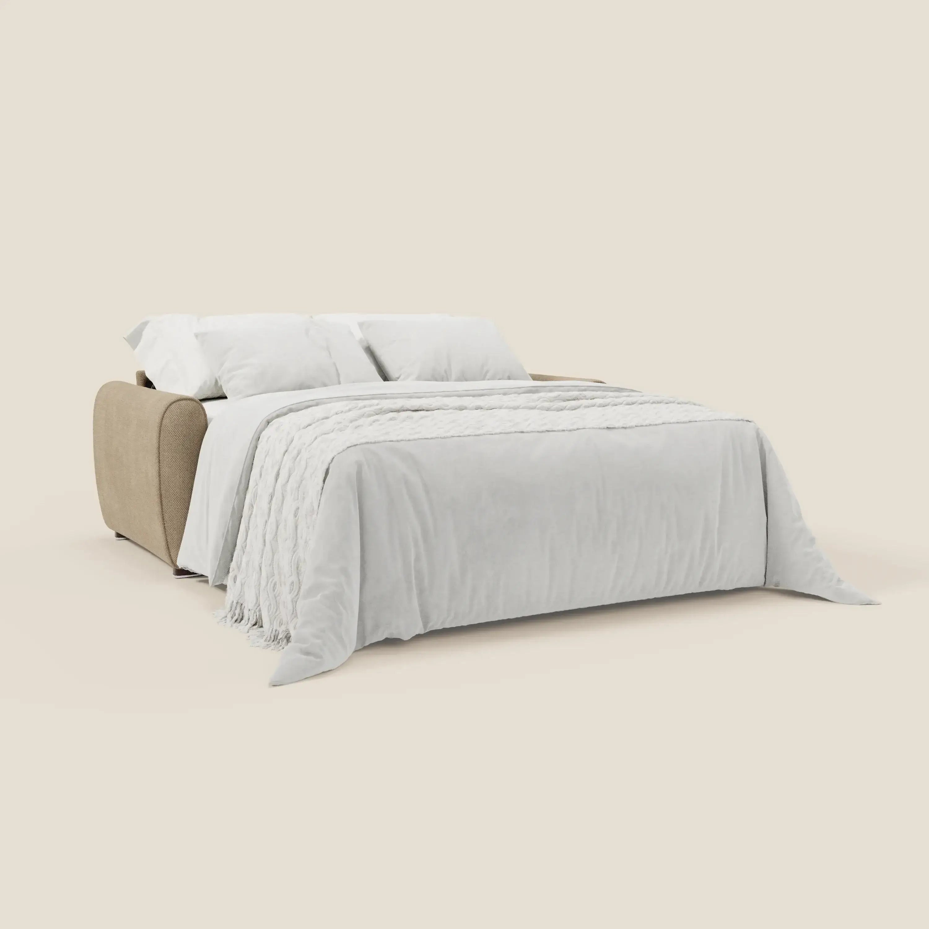 Il Kaleo Divano letto moderno con materasso H17 cm di Divani.Store, in raffinato tessuto impermeabile T26 beige, è aperto a letto con soffice biancheria bianca e due cuscini, su sfondo chiaro. Riflette un elegante design contemporaneo.