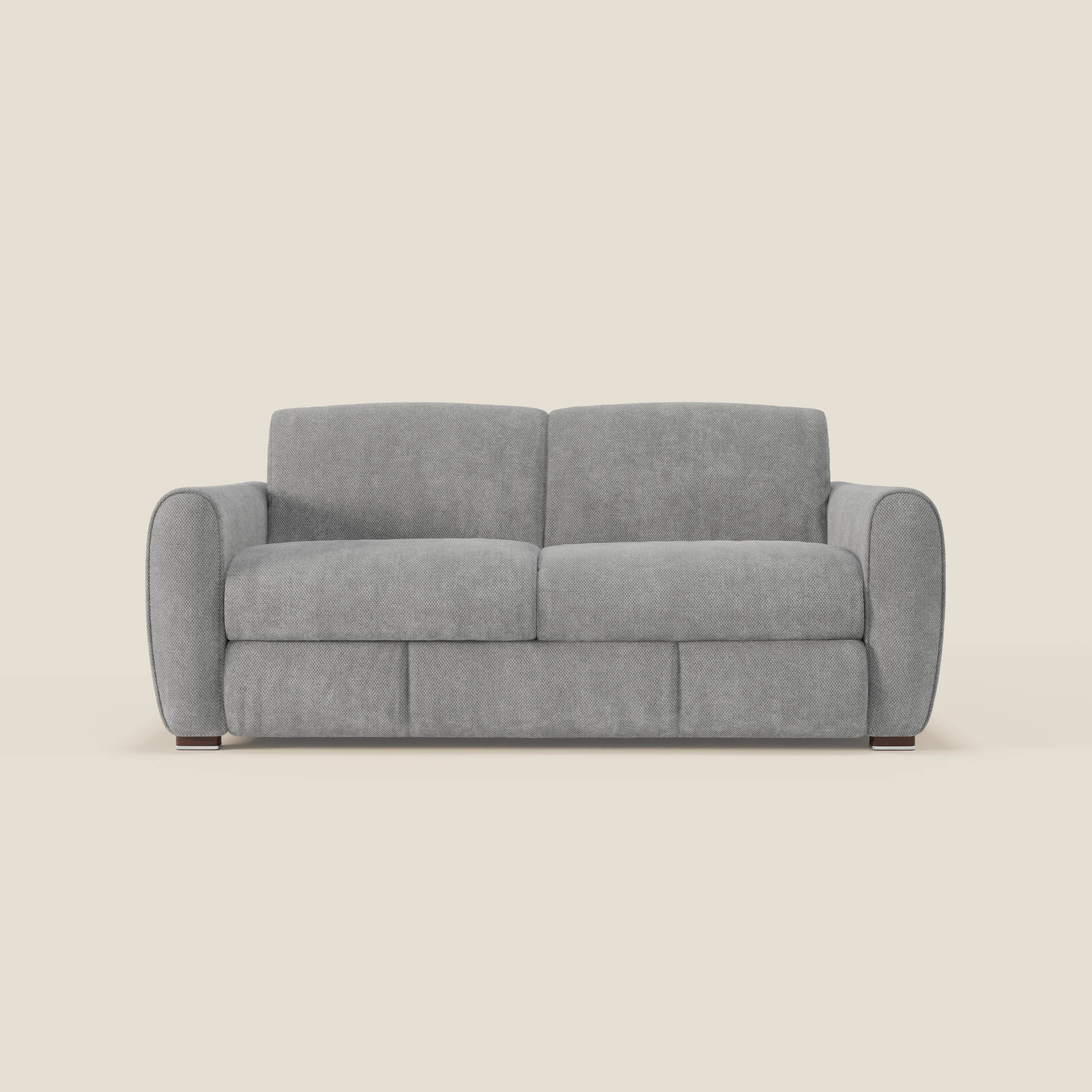 Il divano letto moderno Kaleo di Divani.Store è caratterizzato da tessuto impermeabile T26 grigio chiaro, cuscini morbidi, braccioli arrotondati, linee pulite e gambe corte in legno scuro.