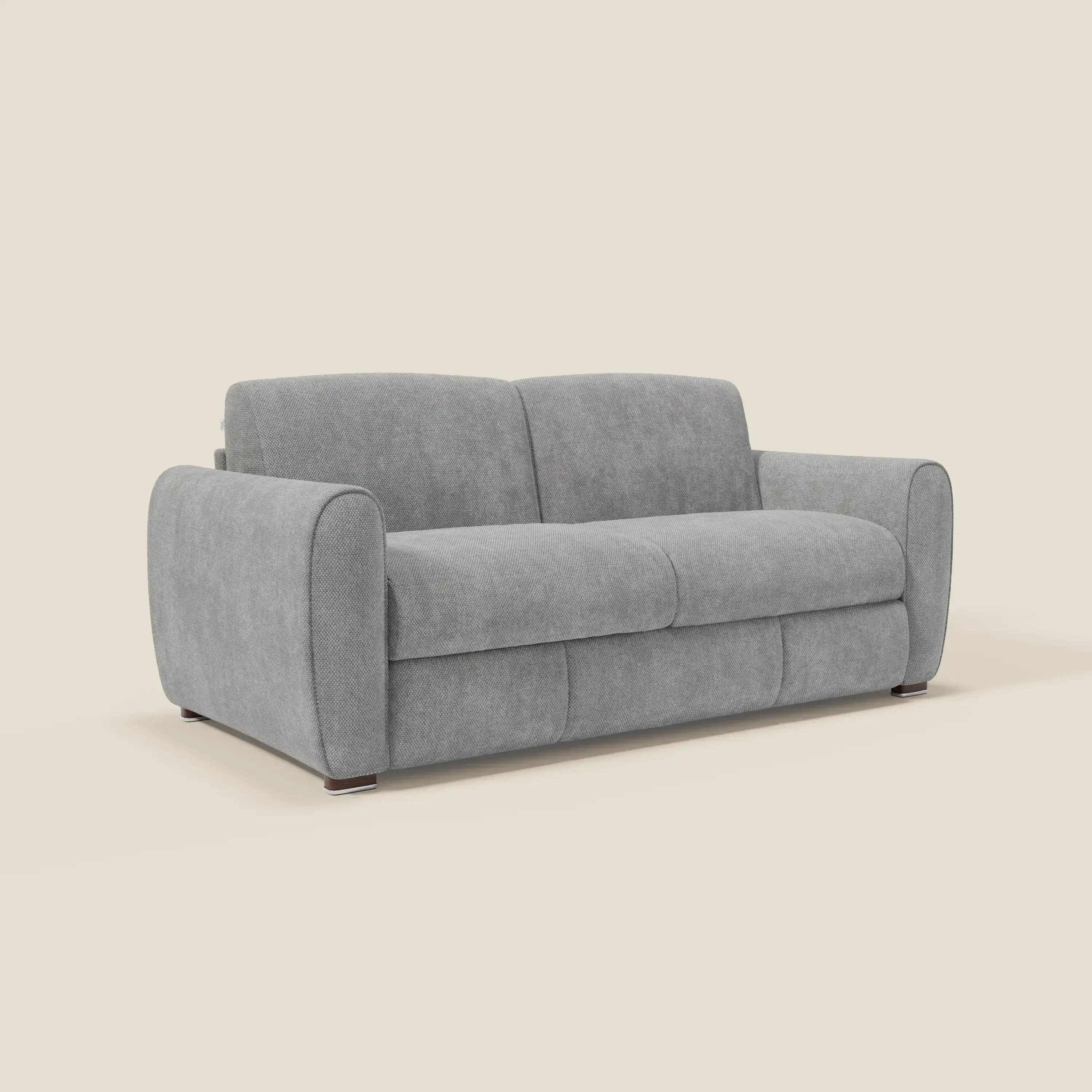 Il Kaleo Divano letto moderno di Divani.Store, in tessuto impermeabile T26 grigio, vanta cuscini plush, braccioli arrotondati e piedi bassi in legno. Il materasso H17 cm ad alta densità offre comfort e supporto su uno sfondo bianco sporco.