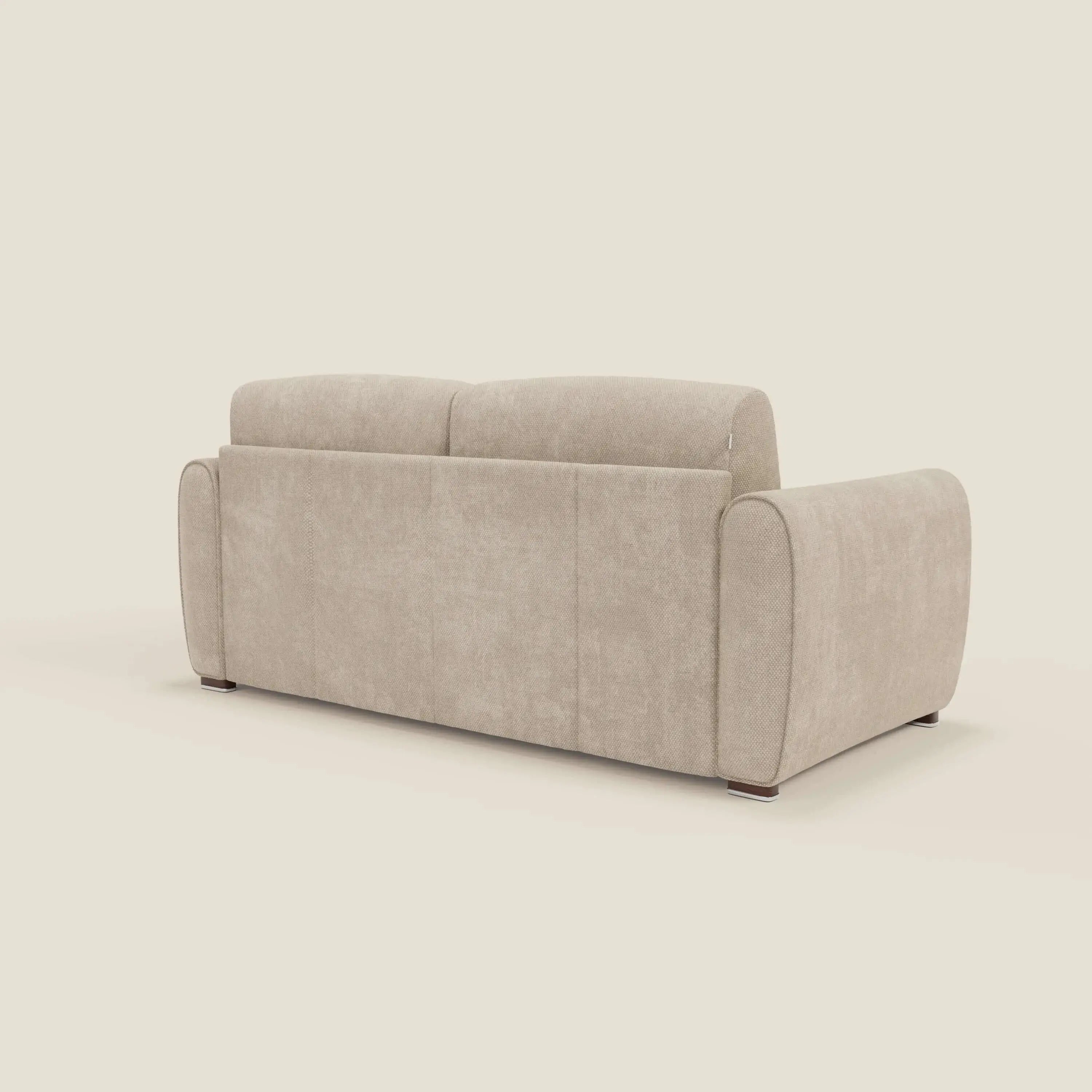 Il Kaleo Divano letto moderno di Divani.Store, presentato nella versione posteriore e laterale in tessuto impermeabile T26 panna, è caratterizzato da ampi braccioli arrotondati, schienale basso, gambe corte in legno scuro e materasso da 17 cm su sfondo crema.