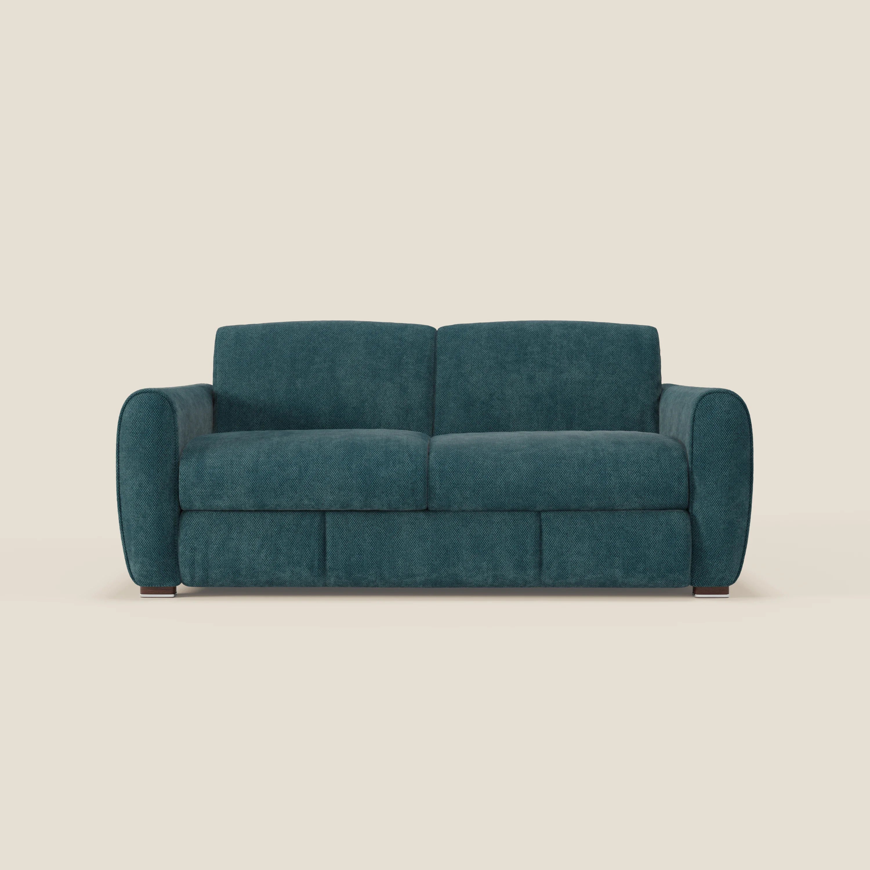Il Kaleo Divano letto moderno di Divani.Store, in tessuto impermeabile T26 petrolio, è caratterizzato da cuscini rettangolari, braccioli arrotondati, profilo basso e sottili piedini in legno su uno sfondo bianco sporco.
