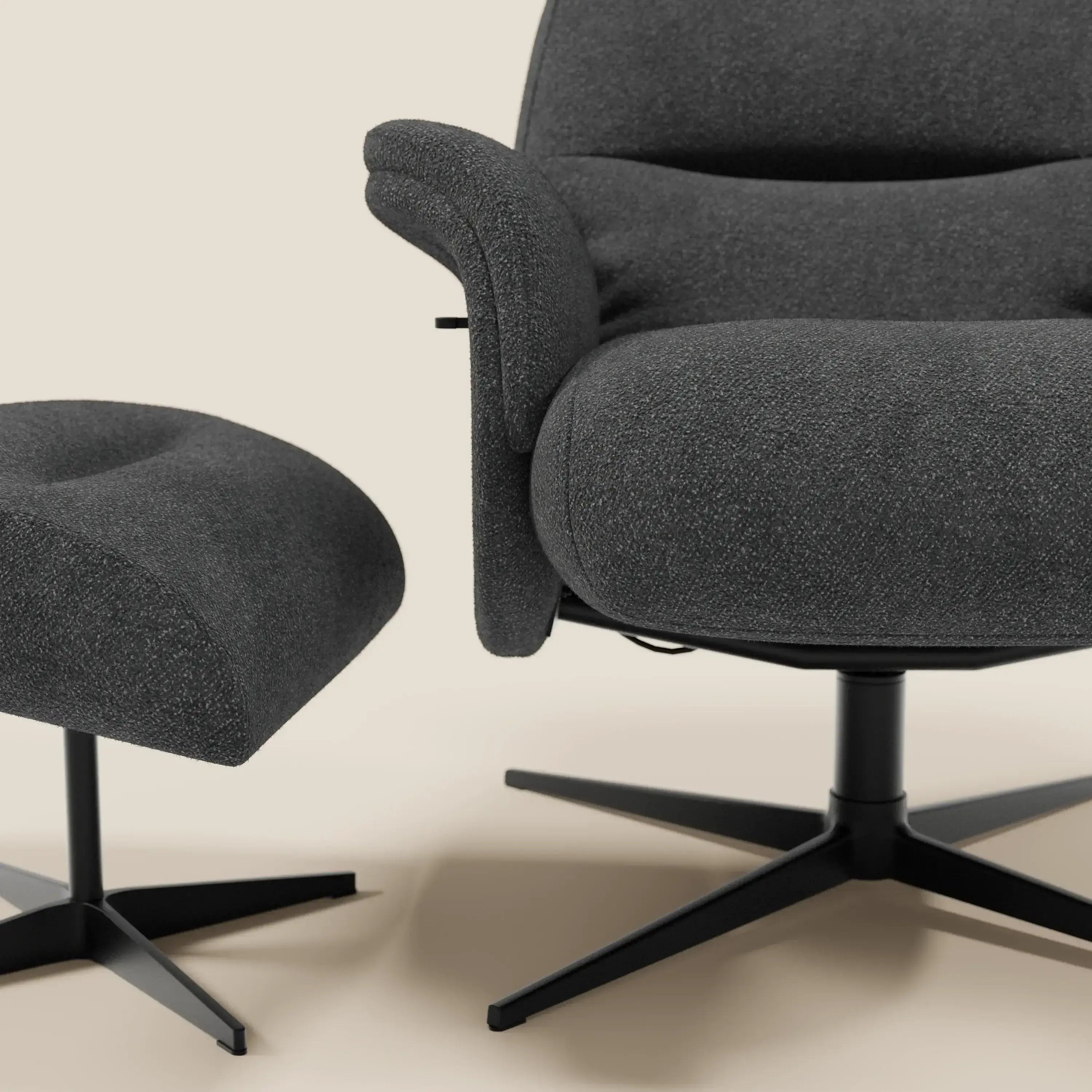 Primo piano della Poltrona relax Lunor reclinabile con pouf poggiapiedi in tessuto bouclé impermeabile T07 antracite di Divani.Store, entrambi con braccioli curvi e basi a quattro punte in nero opaco. Lo sfondo è un semplice beige chiaro; si vede solo in parte.