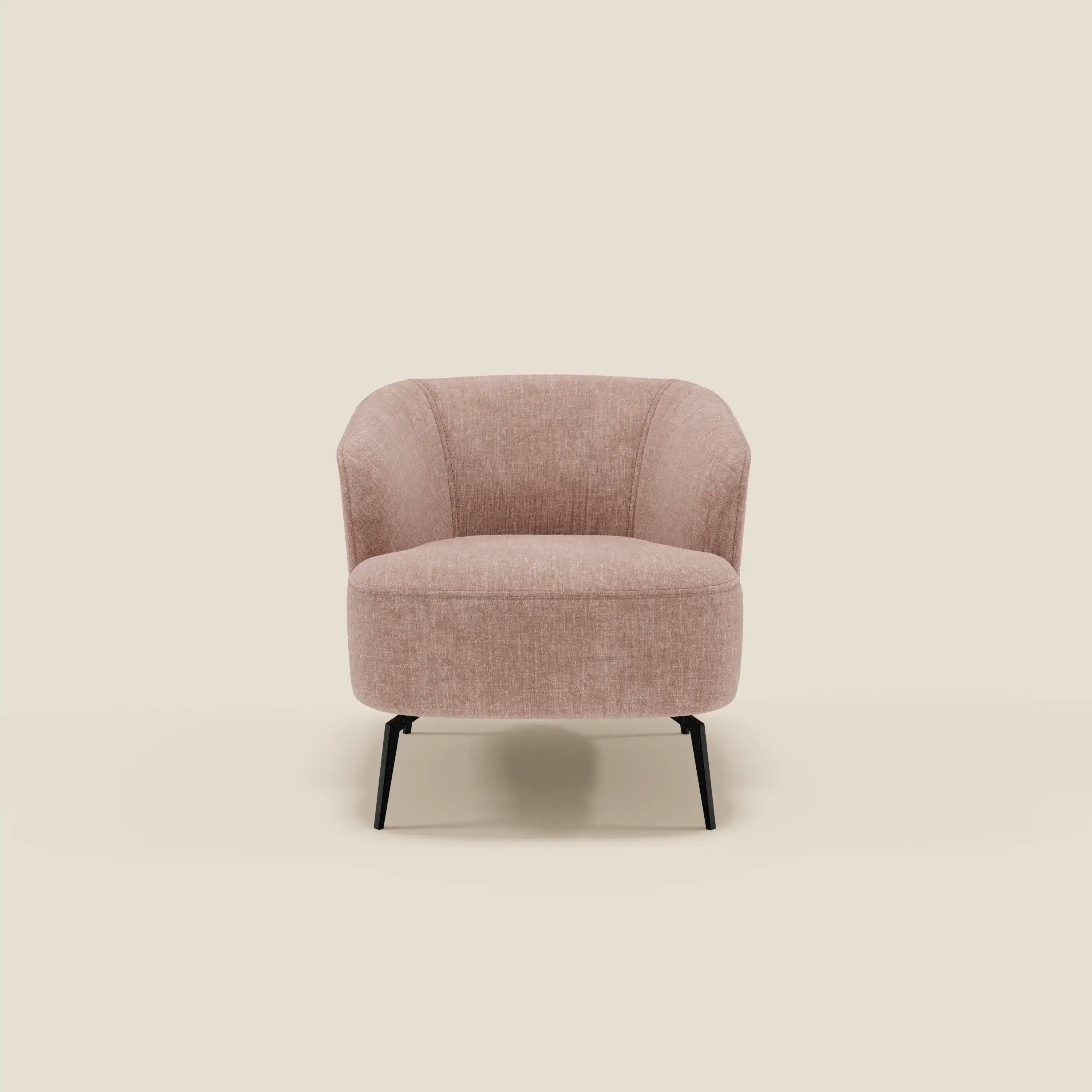 La poltroncina Renoa dall'eleganza moderna in tessuto smacchiabile T24 rosa cipria di Divani.Store è caratterizzata da uno schienale e da una seduta curvi su sottili gambe in metallo nero, presentate al centro di un semplice sfondo beige chiaro per un look minimalista.