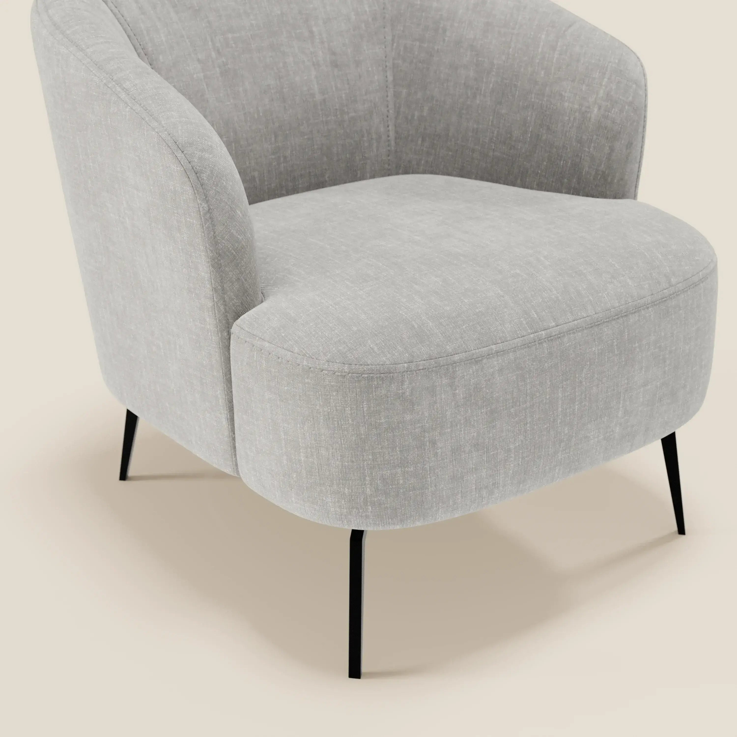 La poltroncina Renoa dall'eleganza moderna di Divani.Store è caratterizzata da tessuto smacchiabile T24 grigio, schienale e seduta arrotondati e sottili gambe in metallo nero. Presentato su uno sfondo beige, il suo design moderno combina comfort e stile.