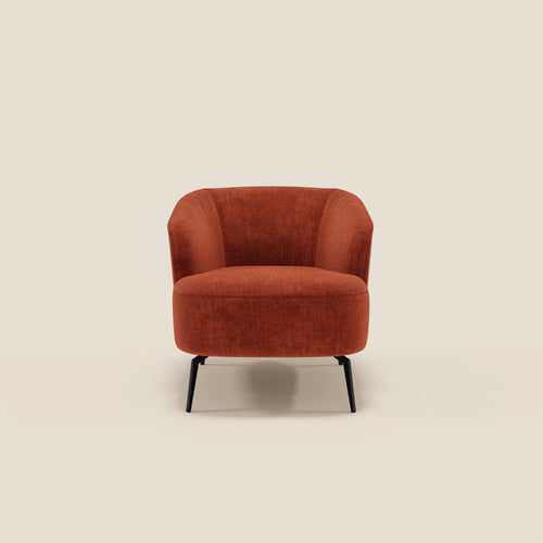La Renoa Poltroncina di Divani.Store, dall'eleganza moderna, è rivestita in tessuto smacchiabile T24 ruggine con schienale e seduta arrotondati e sottili gambe in metallo nero. Sfondo beige chiaro minimalista.