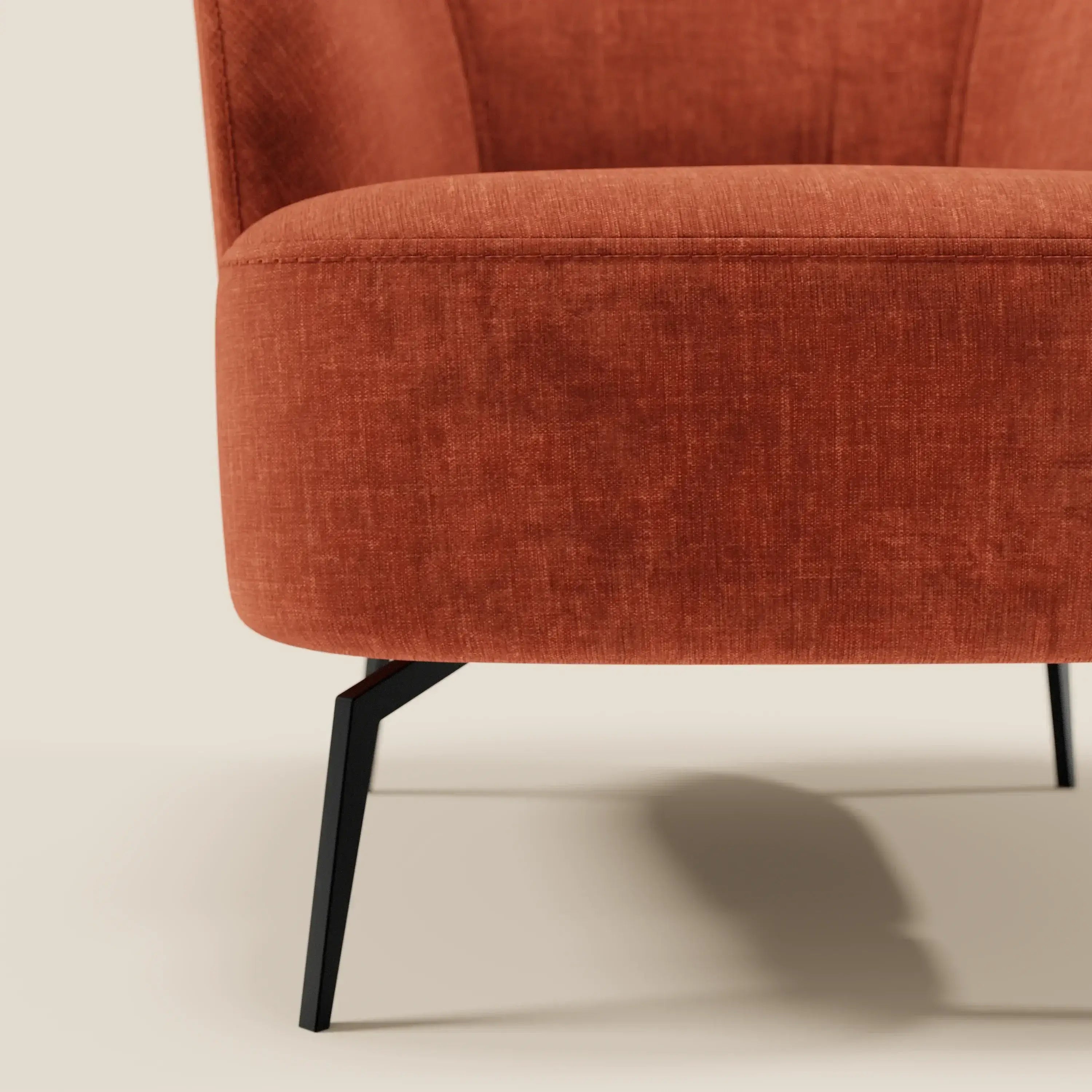 Primo piano della poltroncina Renoa dall'eleganza moderna in tessuto smacchiabile T24 di Divani.Store, con gambe angolari in metallo nero. Il fondo bianco sporco ne evidenzia l'aspetto moderno ed elegante, perfetto per gli spazi contemporanei.