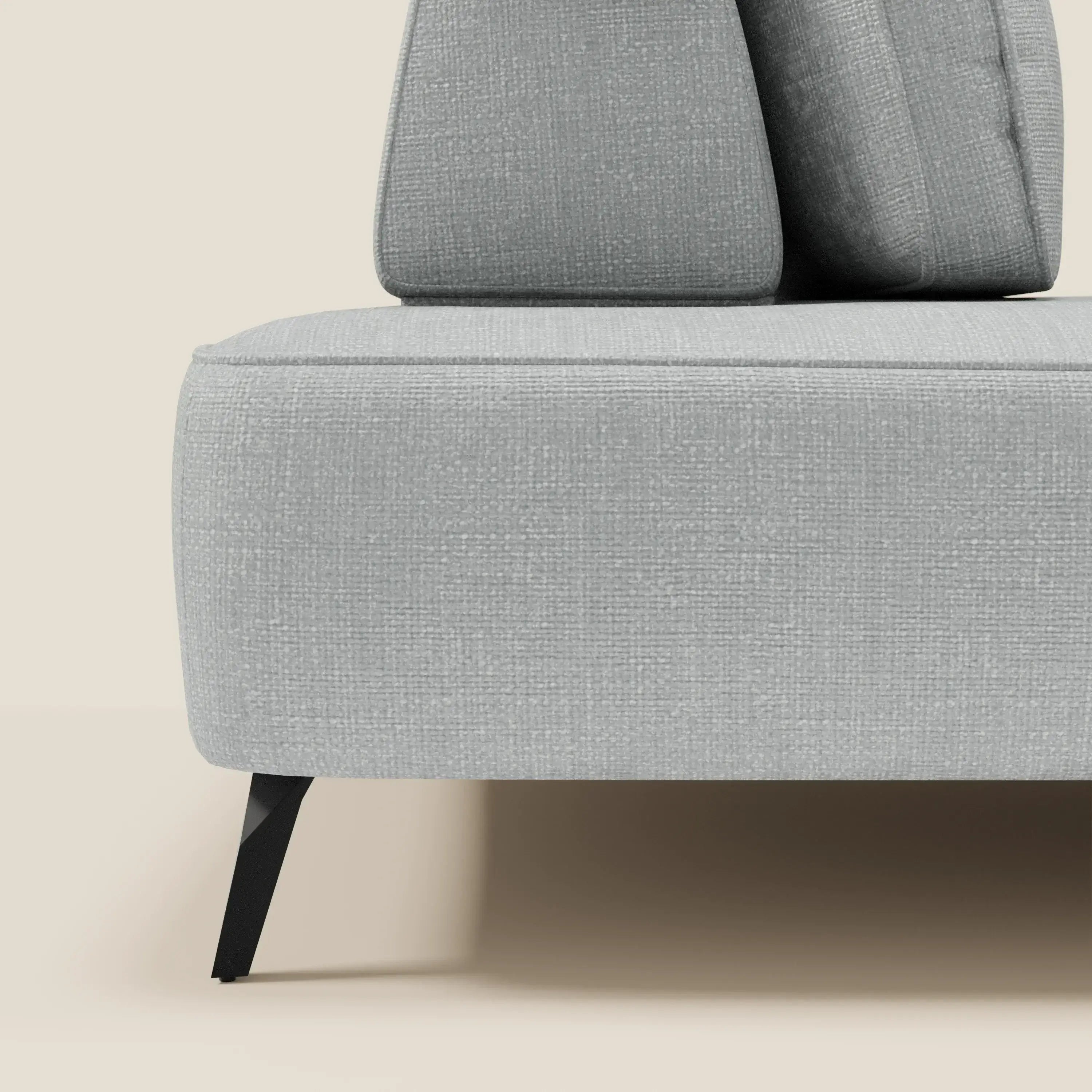 Primo piano del divano modulare Volta con schienali mobili in raffinato tessuto ciniglia T06 ghiaccio di Divani.Store, con gambe angolari in metallo nero e cuscini di schienale coordinati per un look minimalista e contemporaneo su sfondo beige.