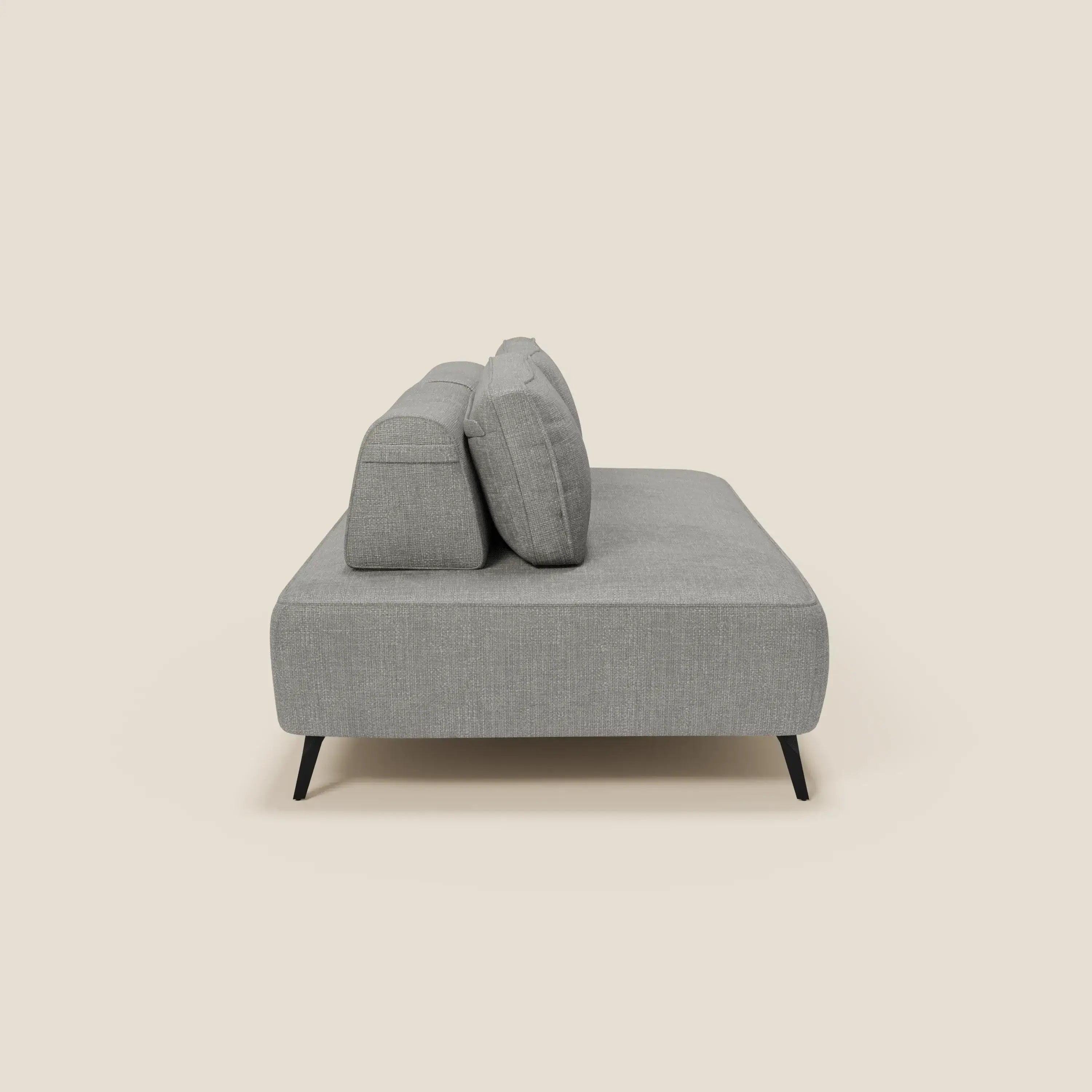 Il divano modulare Volta di Divani.Store in tessuto ciniglia T06 grigio presenta schienali mobili, due cuscini schienale, un design minimalista e gambe nere angolate, mostrato di lato su uno sfondo beige.