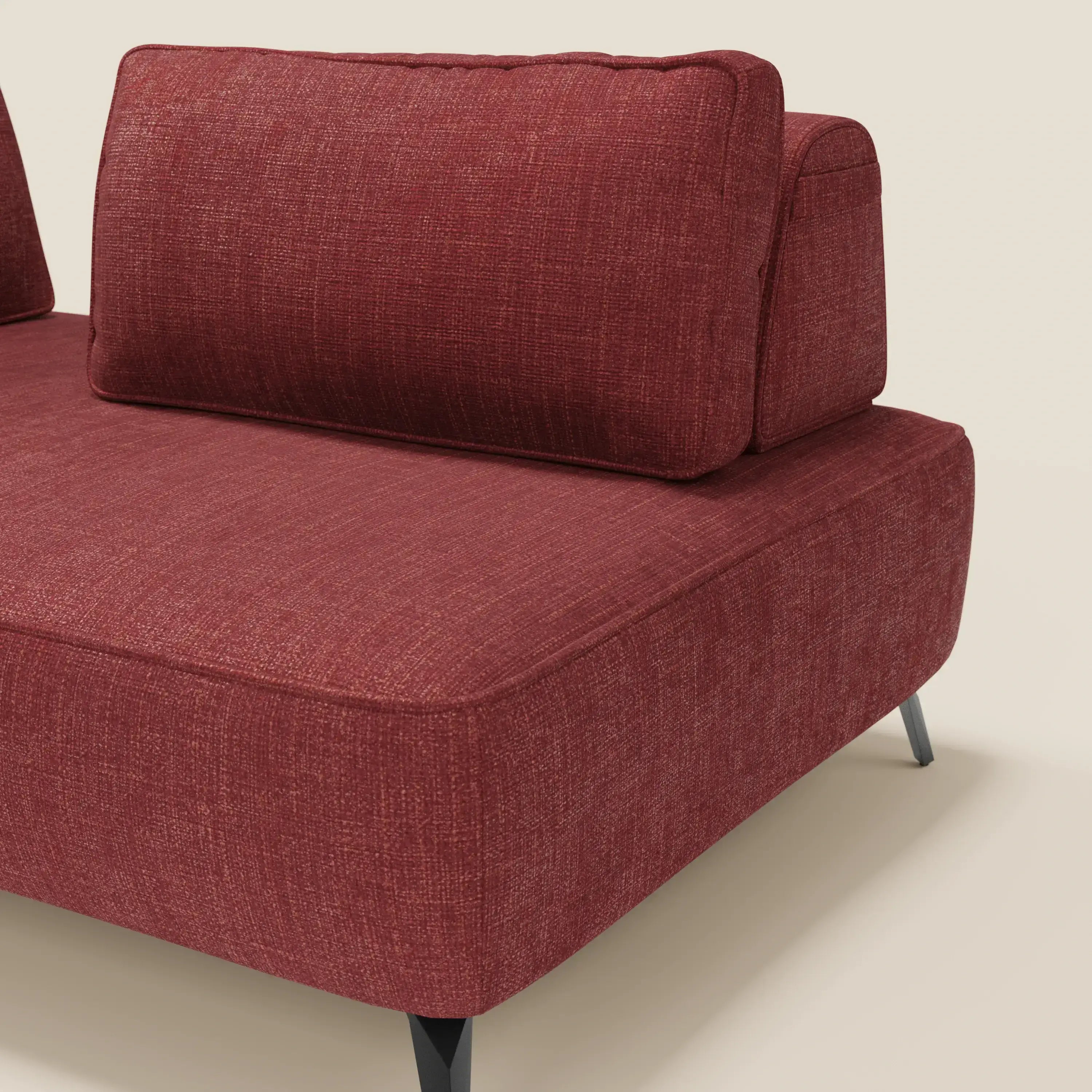 Primo piano del divano modulare Volta con schienali mobili di Divani.Store, in raffinato tessuto ciniglia T06 rosso, caratterizzato da bordi squadrati, spessi cuscini di seduta e di schienale e gambe in metallo angolate nere su uno sfondo bianco sporco.