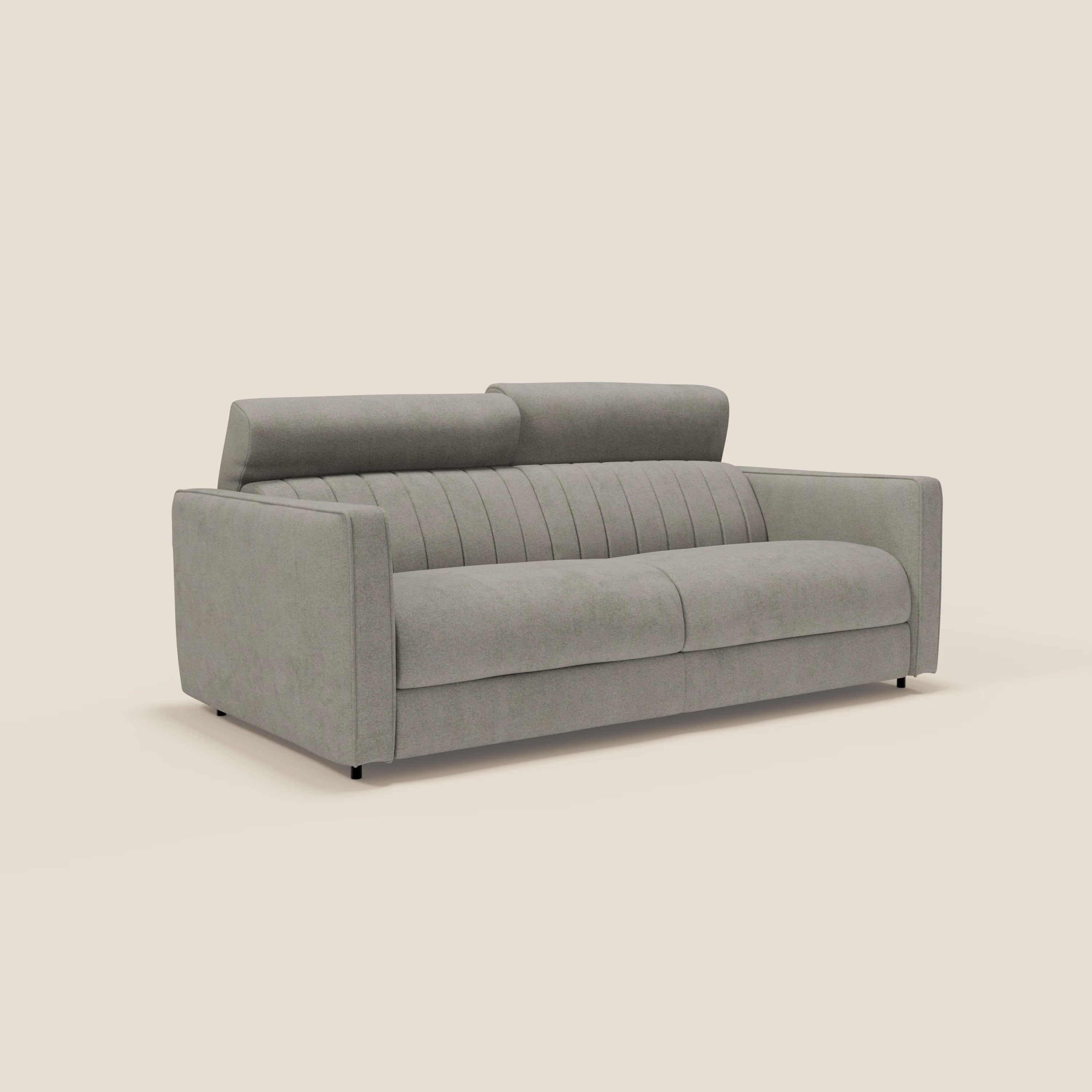 Un moderno divano grigio chiaro con due cuscini di seduta, cuciture verticali sullo schienale, poggiatesta regolabili e ampi braccioli, su uno sfondo beige.