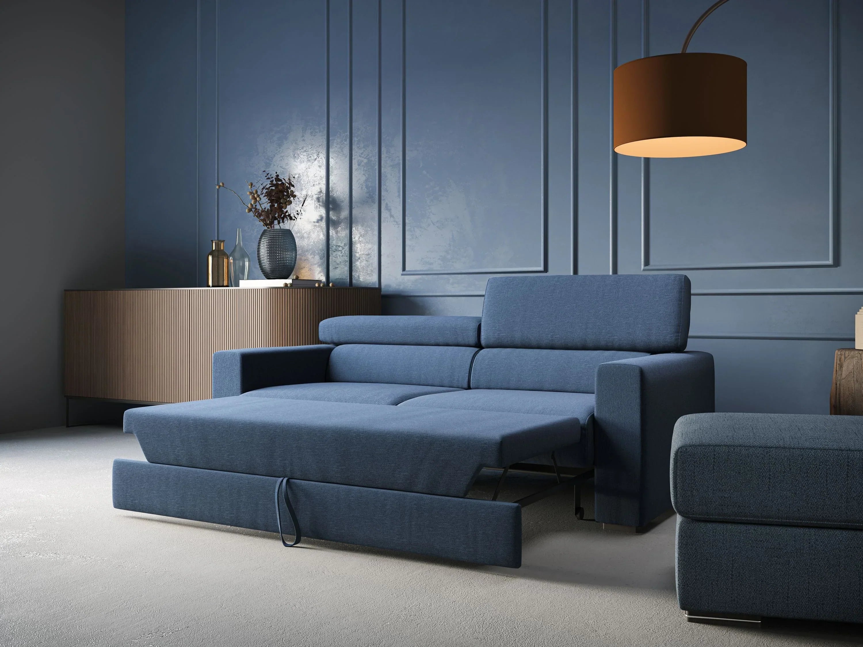 Un soggiorno moderno con pareti blu, un divano letto blu allungato, una credenza in legno con decorazioni e una grande lampada a sospensione marrone. Lo spazio è minimalista ed elegante.