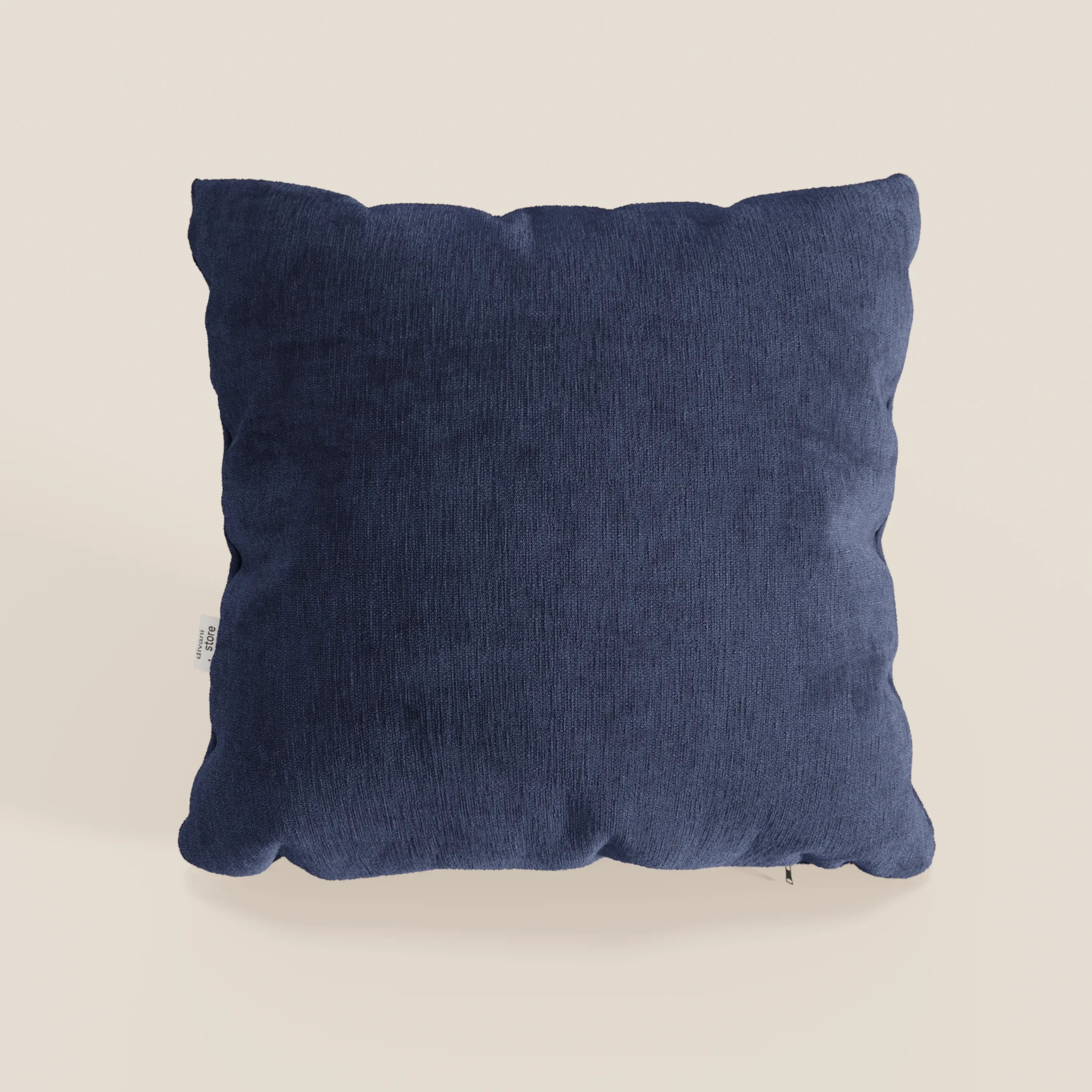 Il cuscino Bolero di Divani.Store, qui presentato in tessuto T31 blu scuro, è caratterizzato da un disegno quadrato morbido, felpato e strutturato con una piccola etichetta bianca e poggia su uno sfondo bianco sporco. Il cuscino è smacchiabile, impermeabile e irrestringibile.