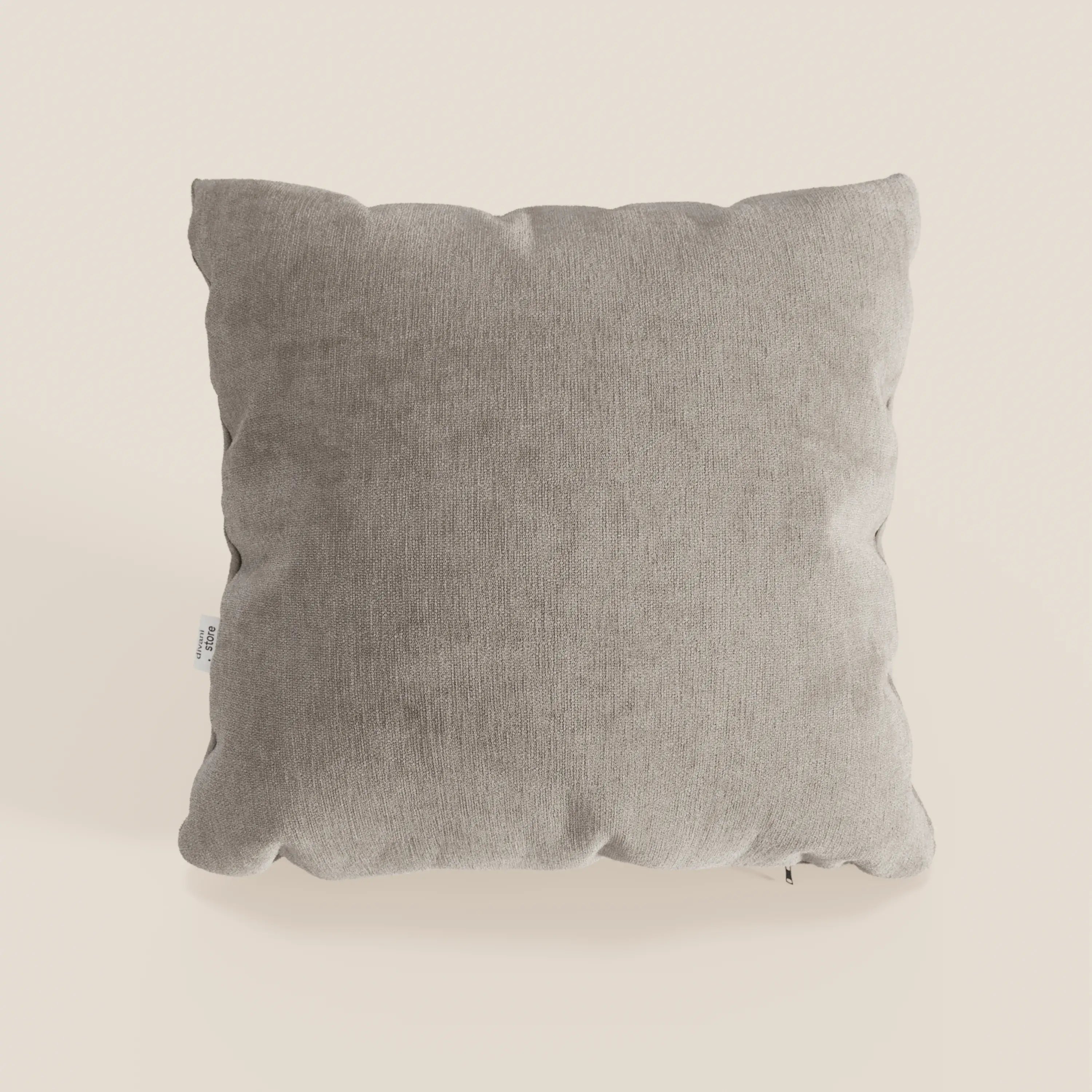 Il cuscino Bolero di Divani.Store è di colore grigio chiaro, con forma quadrata, bordi arrotondati, cuciture a vista e una piccola etichetta bianca. Realizzato in morbido tessuto T31, resistente alle macchie, impermeabile e non restringente.
