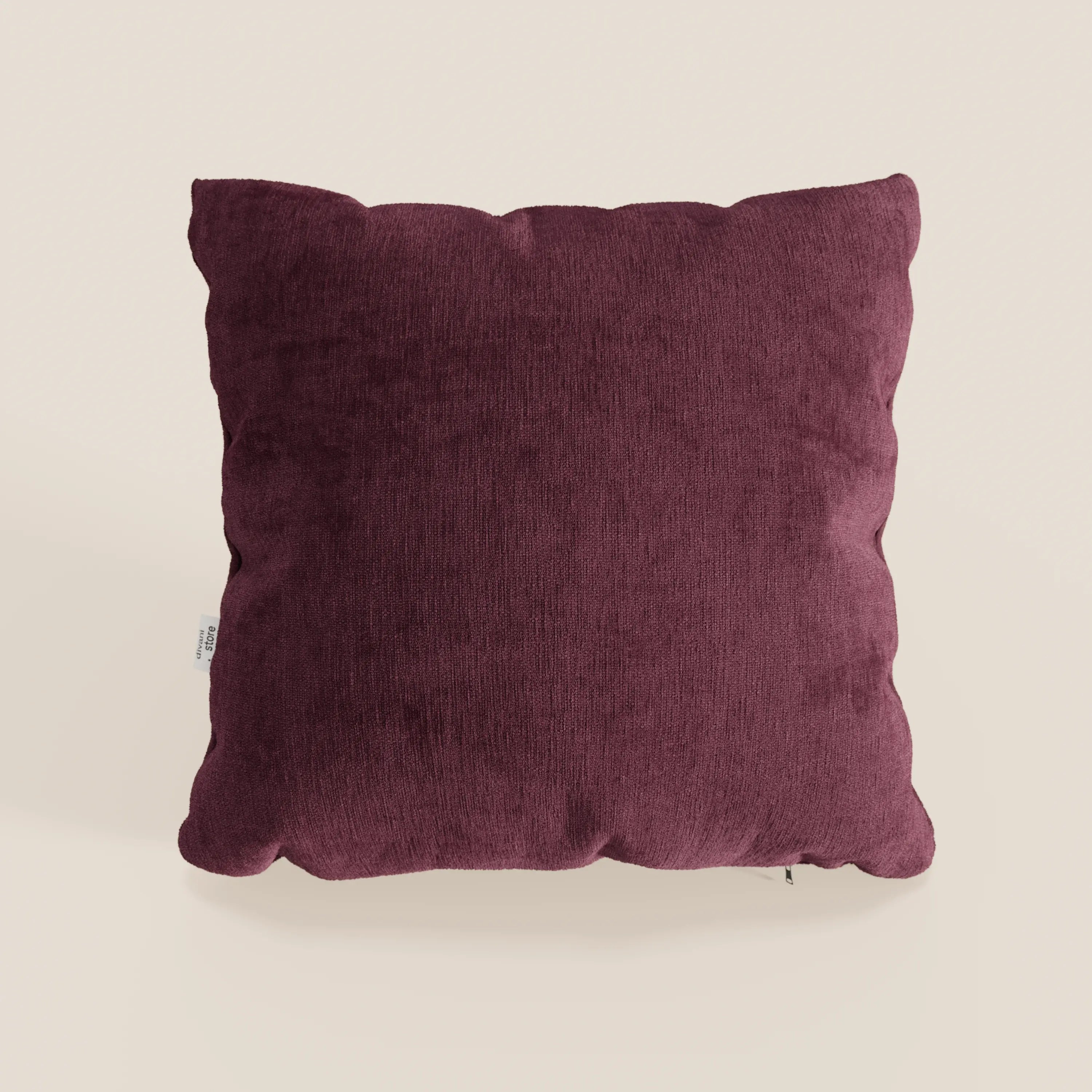Il cuscino Bolero di Divani.Store, qui presentato in un ricco bordeaux con un morbido tessuto smacchiabile T31, presenta una forma quadrata, angoli delicatamente arrotondati, sottili cuciture sui bordi e una piccola etichetta bianca sul lato sinistro.