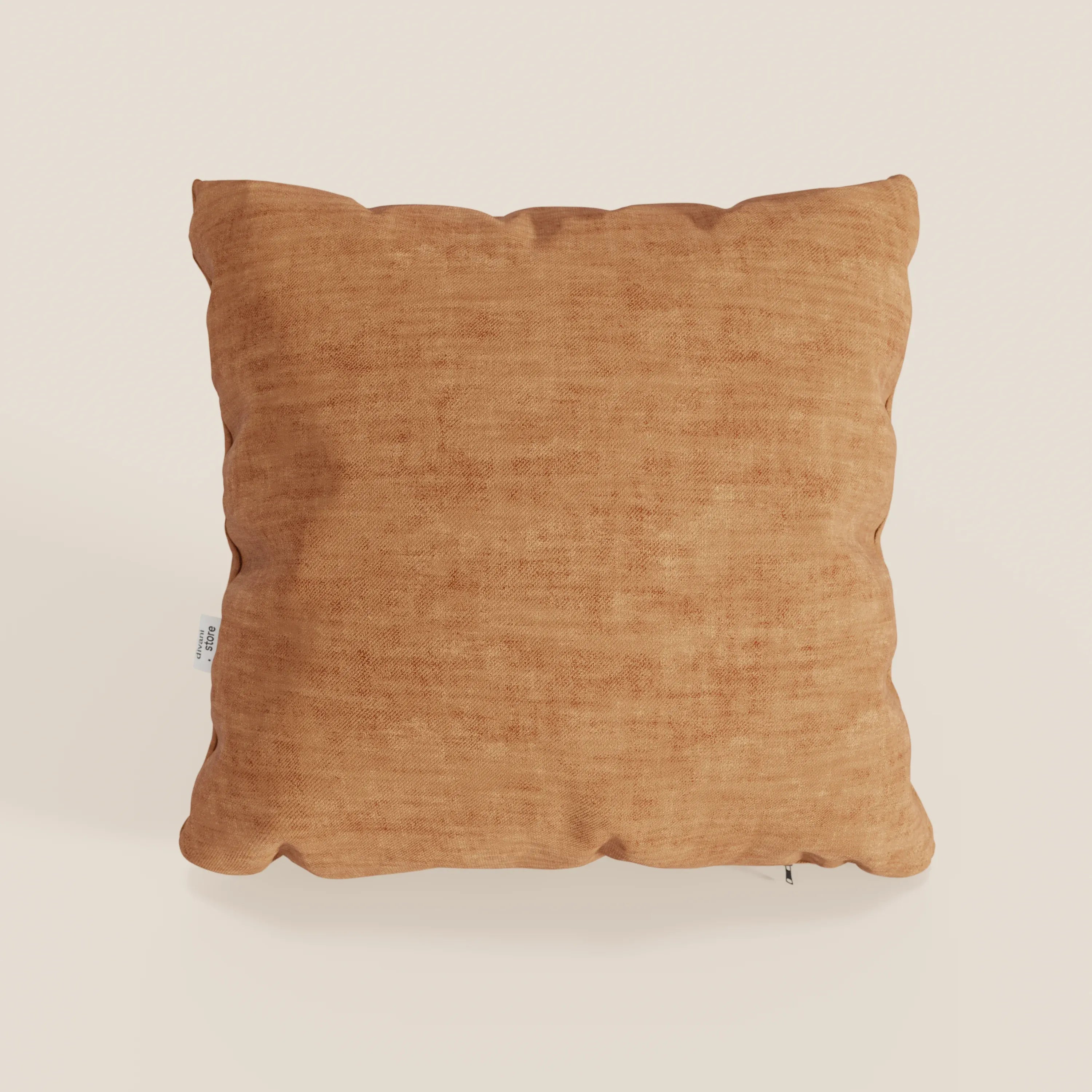 Il cuscino quadrato Sofia di Divani.Store, di colore arancio-marrone, realizzato in morbido velluto Easy Clean T35, antimacchia e impermeabile, è posizionato in verticale su uno sfondo bianco sporco, con un'etichetta laterale bianca e una sottile cerniera in basso a destra.