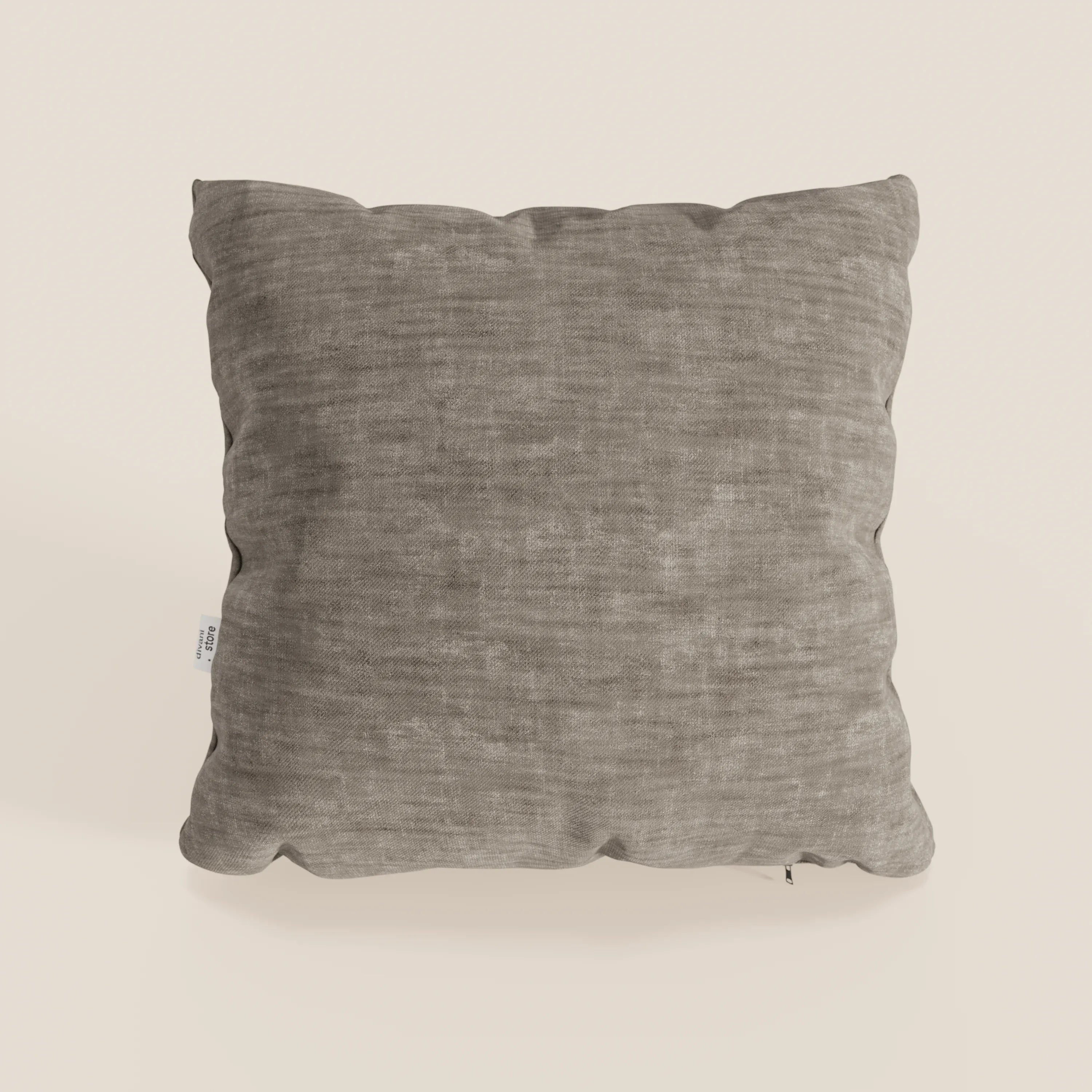 Il cuscino Sofia di Divani.Store, presentato in grigio, ha forma quadrata, angoli arrotondati, morbido velluto nuvolato (smacchiabile e impermeabile Easy Clean T35), pieghe sottili e una piccola etichetta in tessuto bianco sul lato sinistro su uno sfondo bianco sporco.