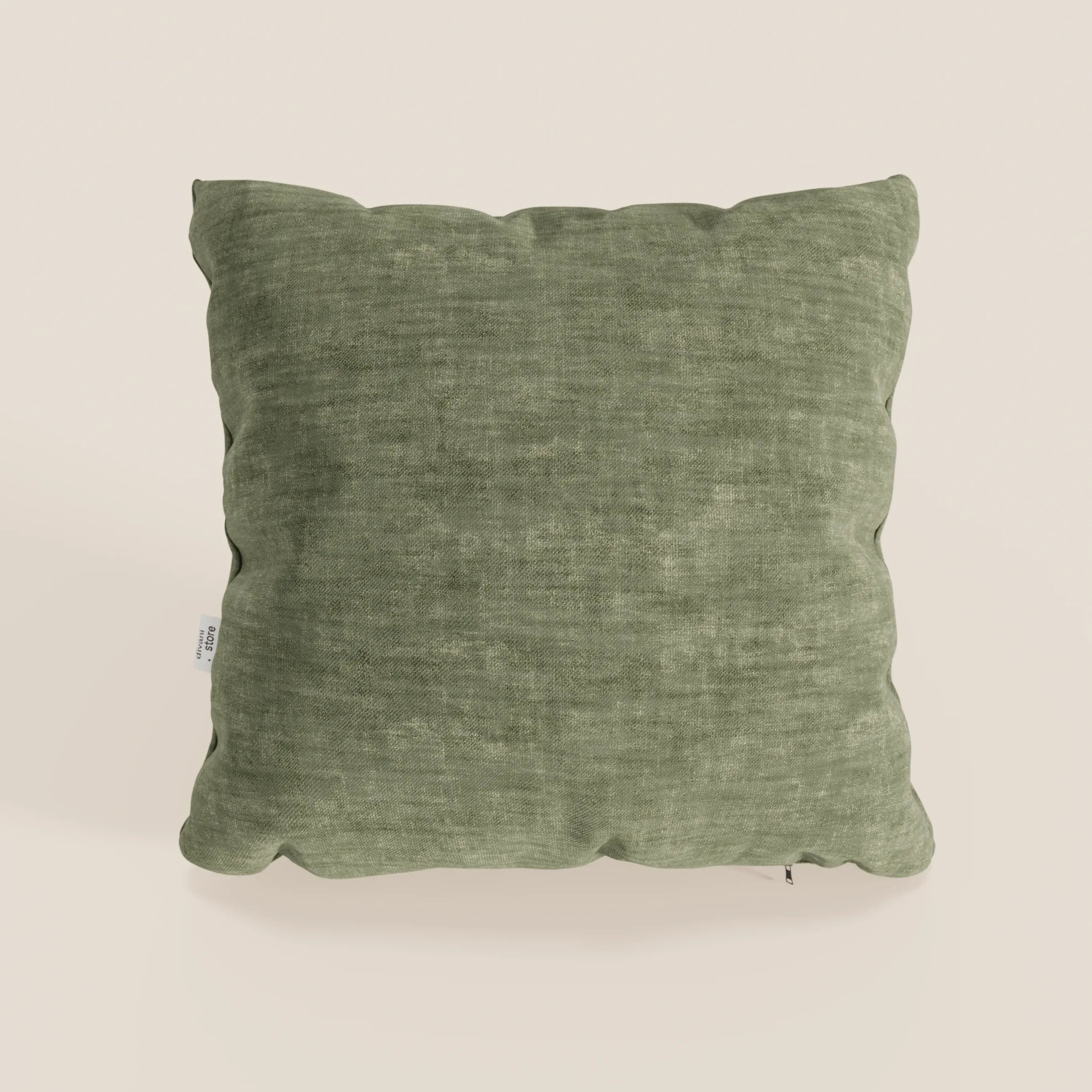 Il cuscino Sofia di Divani.Store, nel colore verde muschio, è un cuscino decorativo quadrato realizzato in morbido velluto Easy Clean T35, resistente alle macchie e impermeabile. Il suo aspetto accogliente spicca su uno sfondo beige chiaro.
