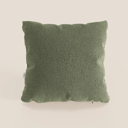 Il cuscino quadrato Lambada verde di Divani.Store poggia su uno sfondo beige chiaro, mostrando il suo sottile motivo intrecciato e gli angoli arrotondati. Realizzato in tessuto smacchiabile e impermeabile T33, fresco e dall'aspetto naturale.