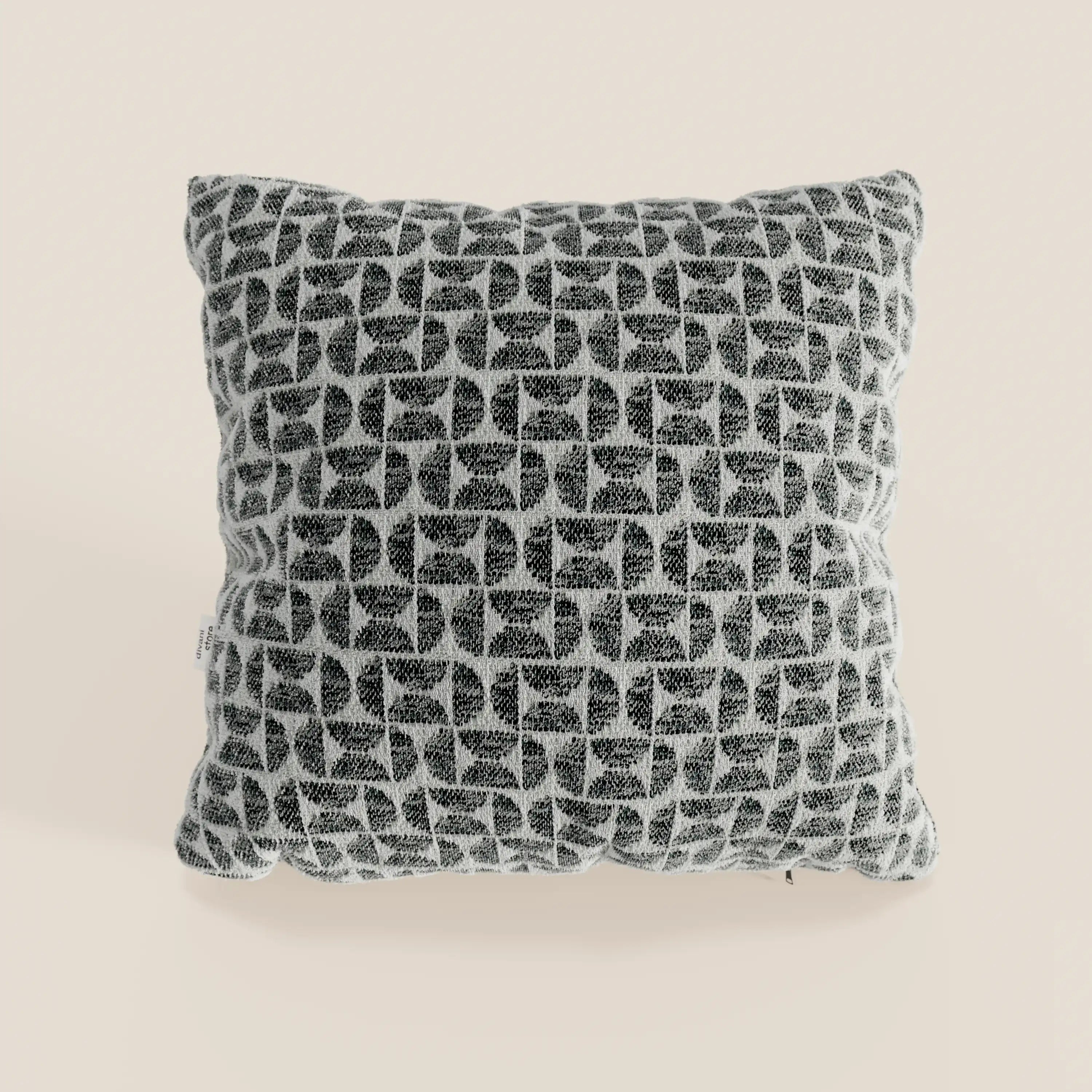 Il cuscino Naxos Cuscino Decoro 45x45 in lino di Divani.Store è un cuscino quadrato in lino con un motivo geometrico in bianco e nero composto da semicerchi intrecciati su fondo beige chiaro, caratterizzato da un aspetto morbido e materico e da una discreta etichetta laterale.