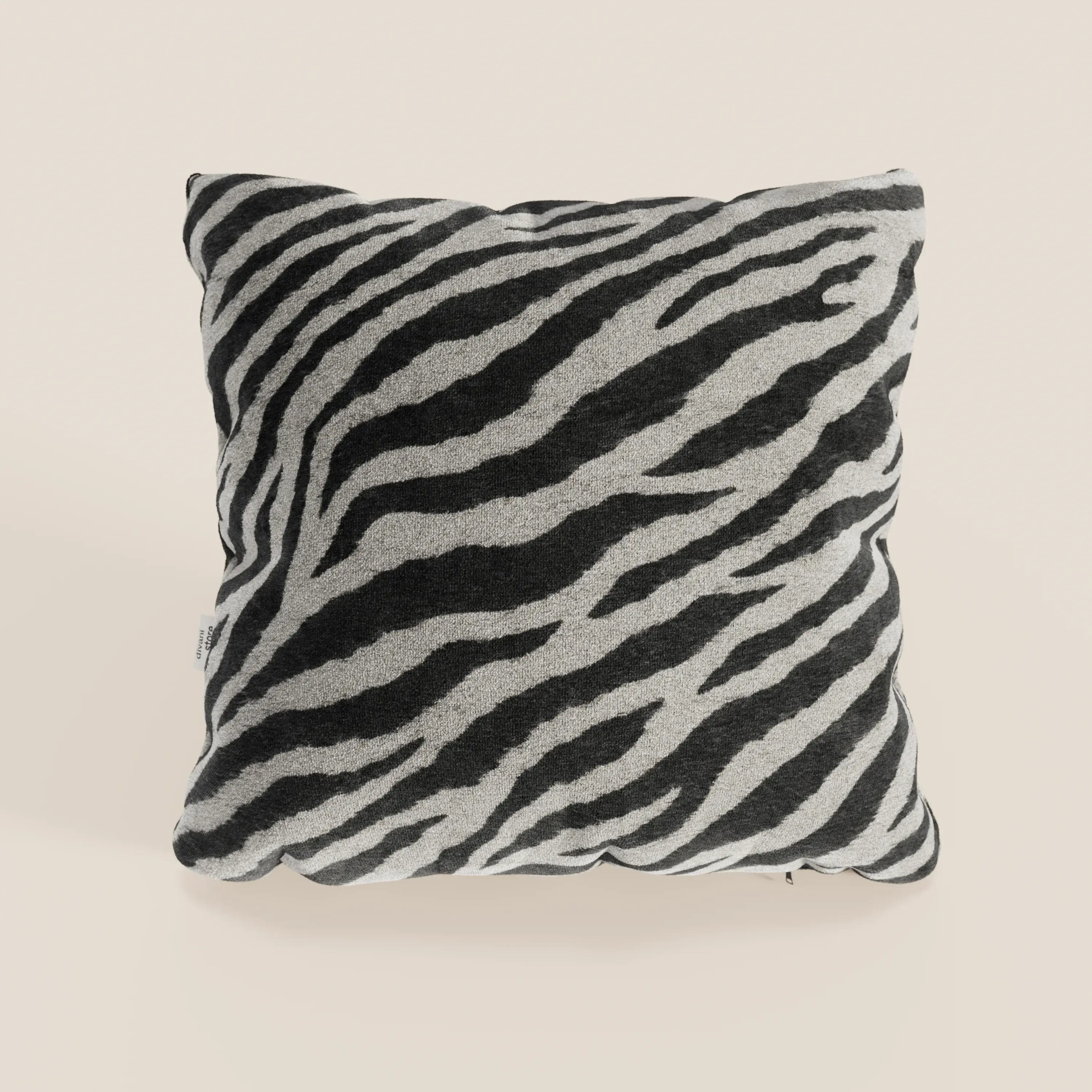 Il cuscino Wild 45x45 di Divani.Store, della collezione Wild, presenta un motivo zebrato bianco e nero in morbido tessuto microfibra impermeabile, appoggiato su uno sfondo beige chiaro con angoli leggermente arrotondati.