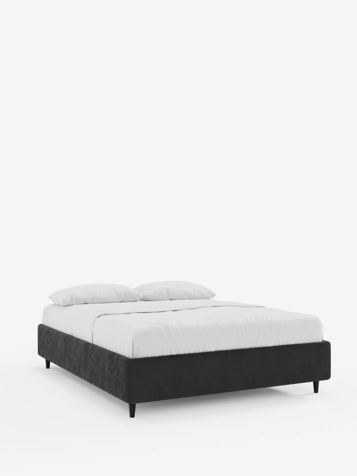 Il letto sommier imbottito ERON con contenitore, rivestito in tessuto impermeabile certificato Oeko-Tex, poggia su corte gambe nere ed è caratterizzato da biancheria da letto di un bianco brillante e da due cuscini coordinati che risaltano su uno sfondo chiaro e sobrio.
