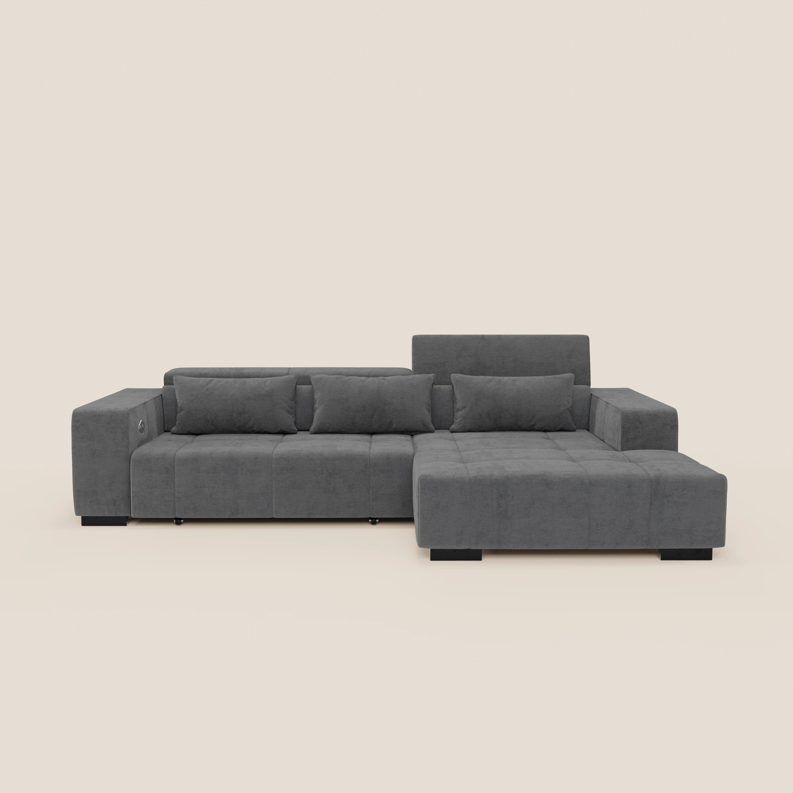Il divano Monarch angolare con penisola di Divani.Store, in tessuto morbido smacchiabile T31, ha chaise a destra, tre sedute allungabili con relax elettrico, poggiatesta reclinabili e ampi braccioli su uno sfondo neutro chiaro.