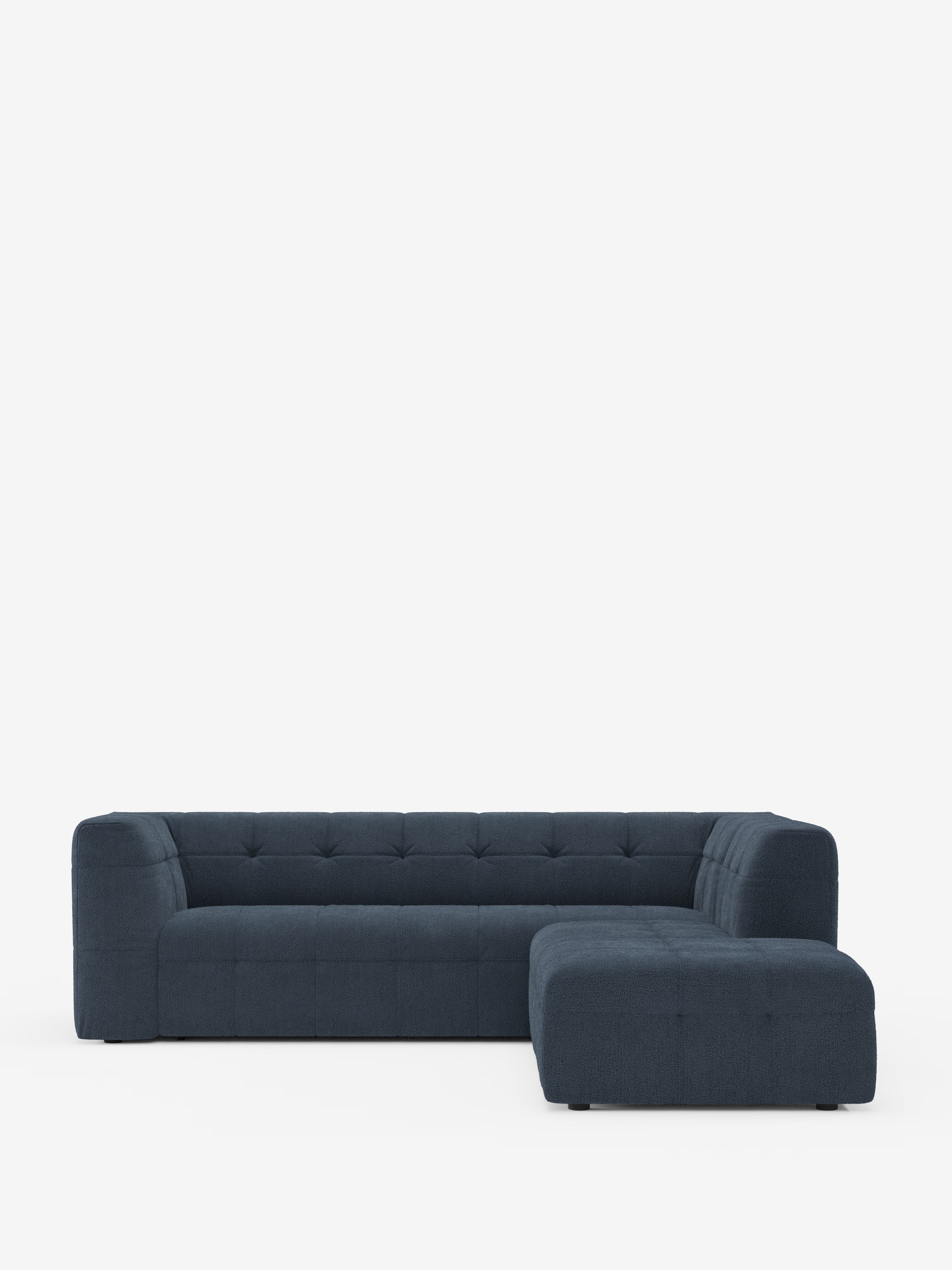 Il divano angolare componibile e modulare Mosaic in bouclé: capitonné e design in tessuto antimacchia T21 di Divani.Store è un moderno divano modulare blu scuro con schienale basso, seduta e schienale trapuntati e morbidi cuscini. Si caratterizza per le linee pulite, il design minimalista e l’elegante rivestimento in bouclé antimacchia, che risalta sullo sfondo bianco a tinta unita.