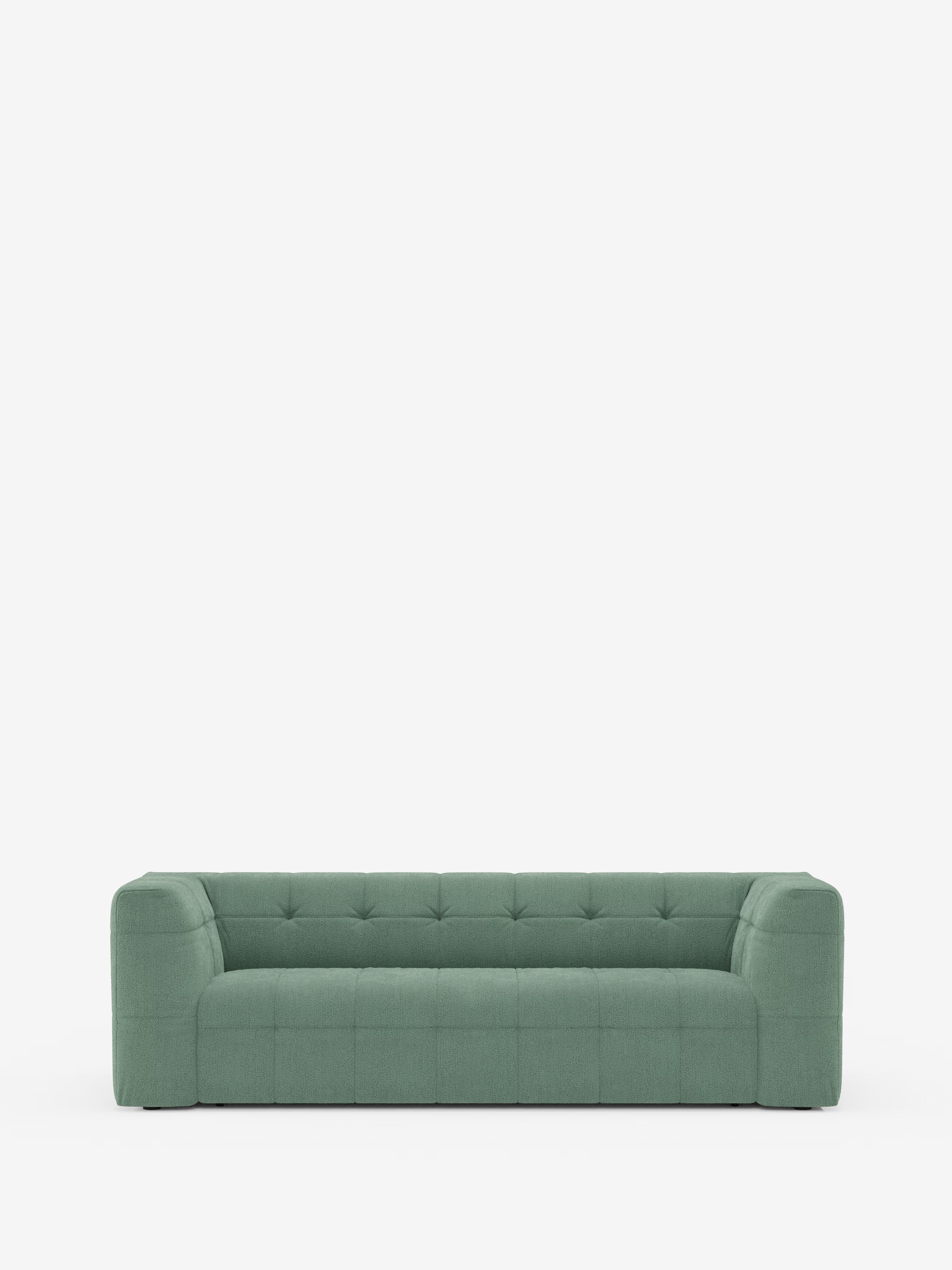 Un divano verde dal design contemporaneo e squadrato — il divano modulare Mosaic a 3 e 4 posti in bouclé di Divani.Store — presenta un rivestimento trapuntato e ampi braccioli ed è posizionato al centro su uno sfondo bianco a tinta unita. Questo divano modulare moderno vanta un design minimalista con profilo ribassato, spigoli squadrati e tessuto T21 lavabile, per un look elegante e contemporaneo.