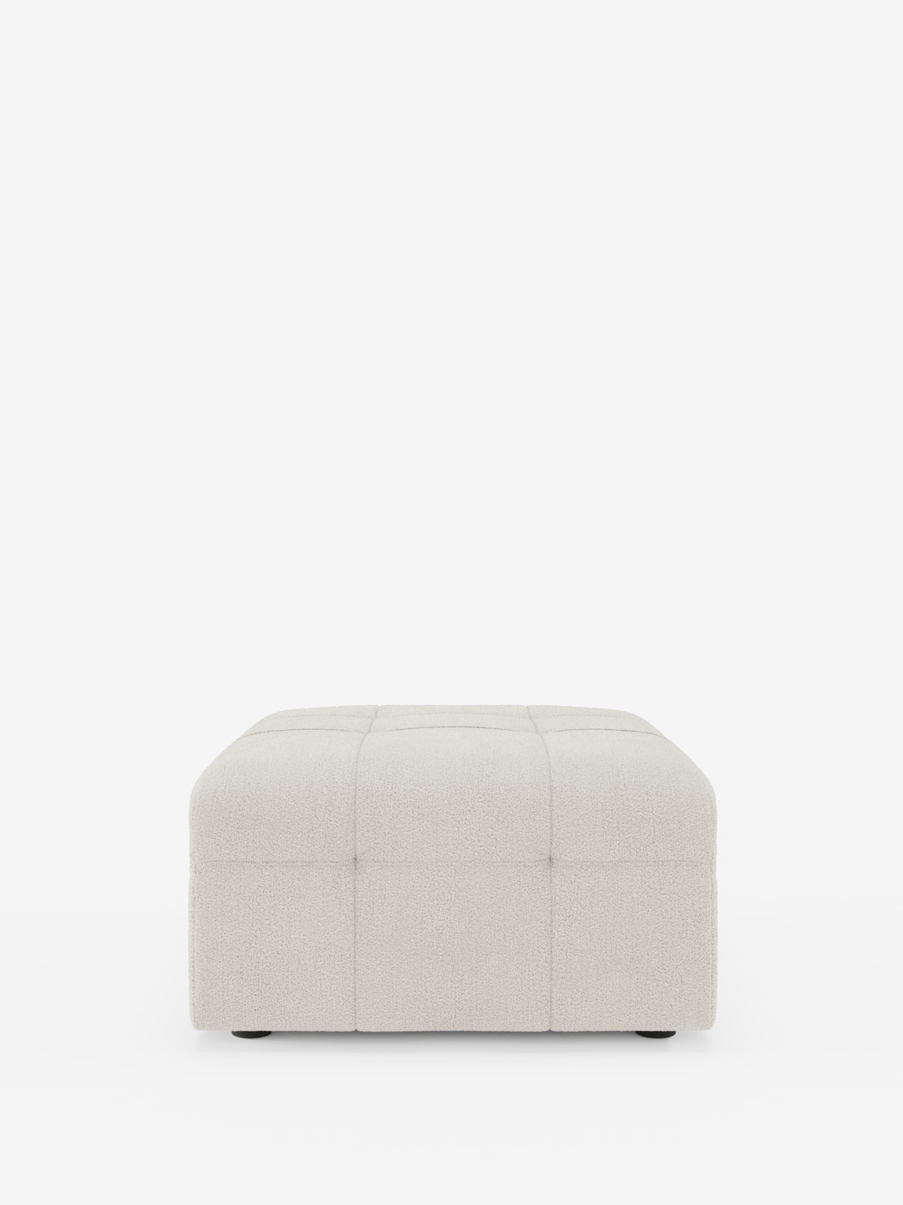 Un pouf quadrato “Mosaic” di colore beige chiaro, realizzato in bouclé da Divani.Store, misura 96x77 cm e presenta un motivo a griglia capitonné in tessuto T21 resistente alle macchie. Visto di fronte su uno sfondo bianco a tinta unita, questo pouf presenta una superficie morbida e ruvida al tatto e poggia direttamente sul pavimento grazie a piedini piccoli e quasi invisibili.
